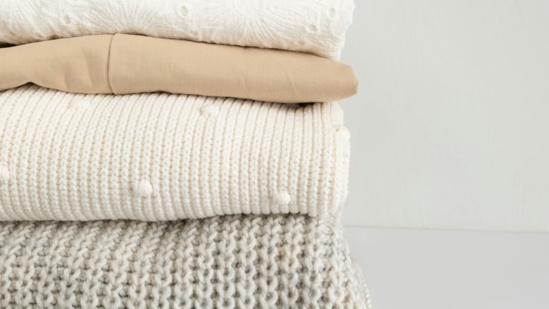 a stack of folded clothes on a white surface