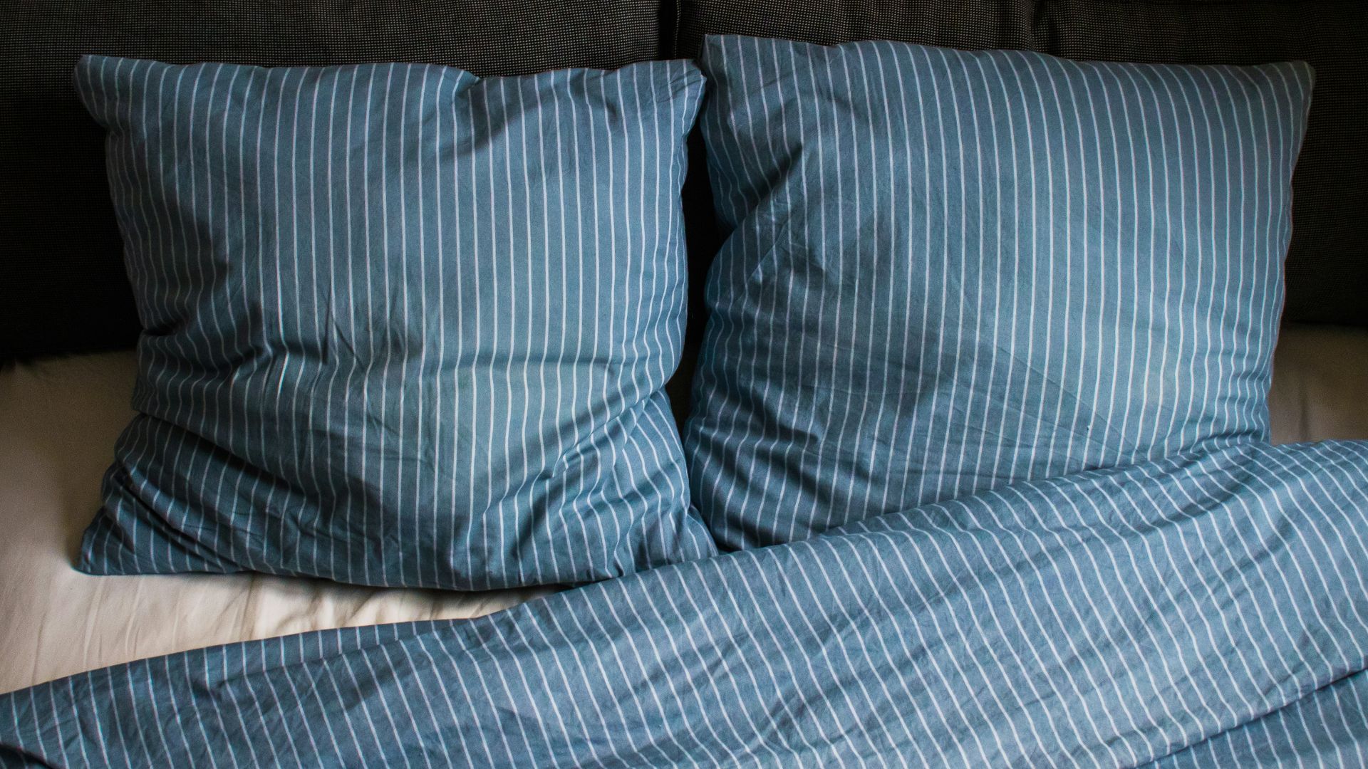 a bed with two pillows and a blanket on top of it