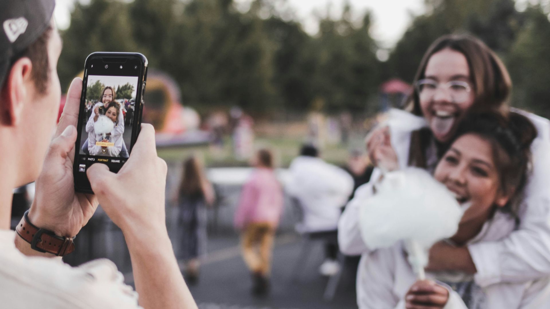woman in white dress holding black smartphone