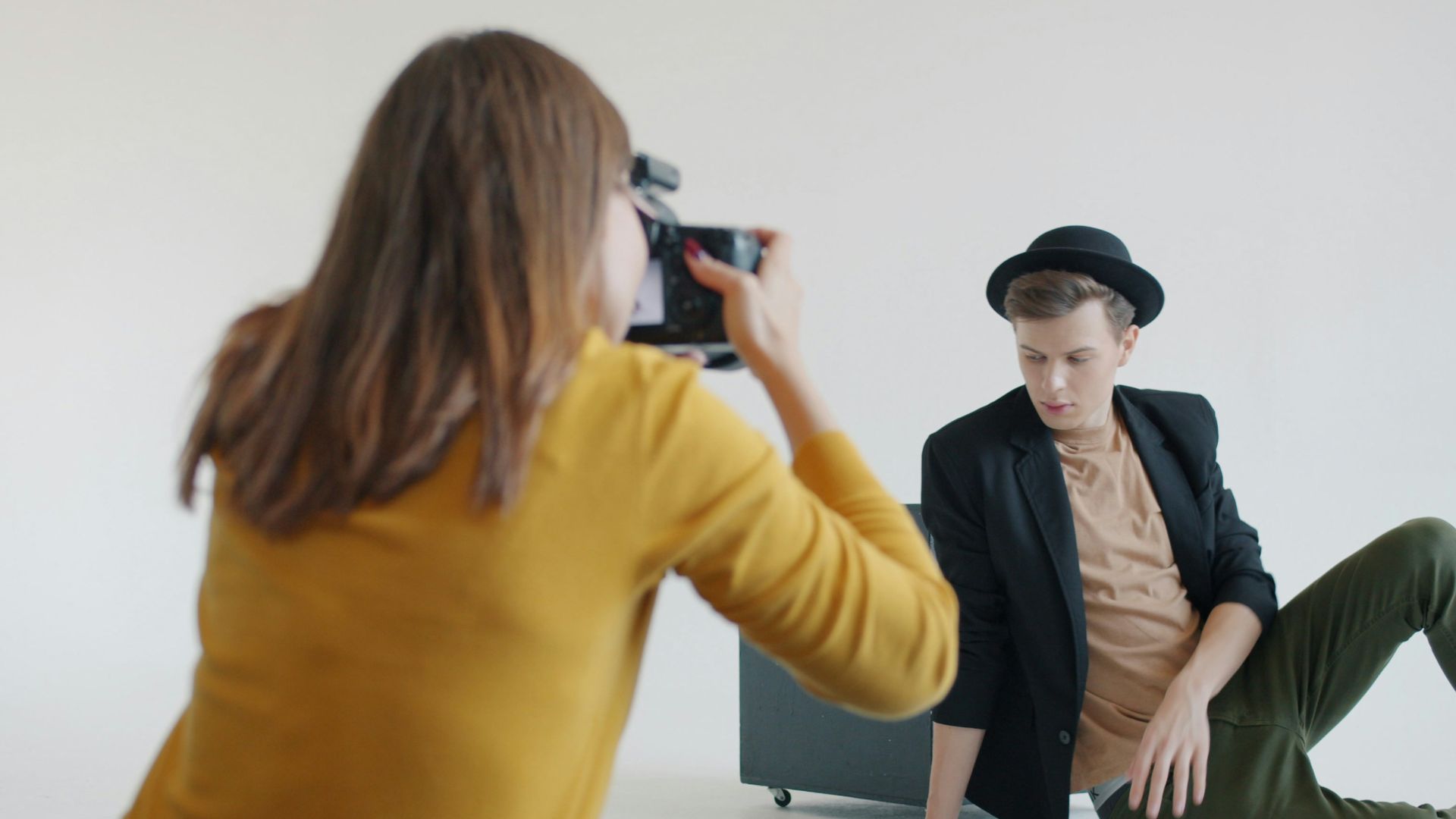 Photographer taking picture of man in hat