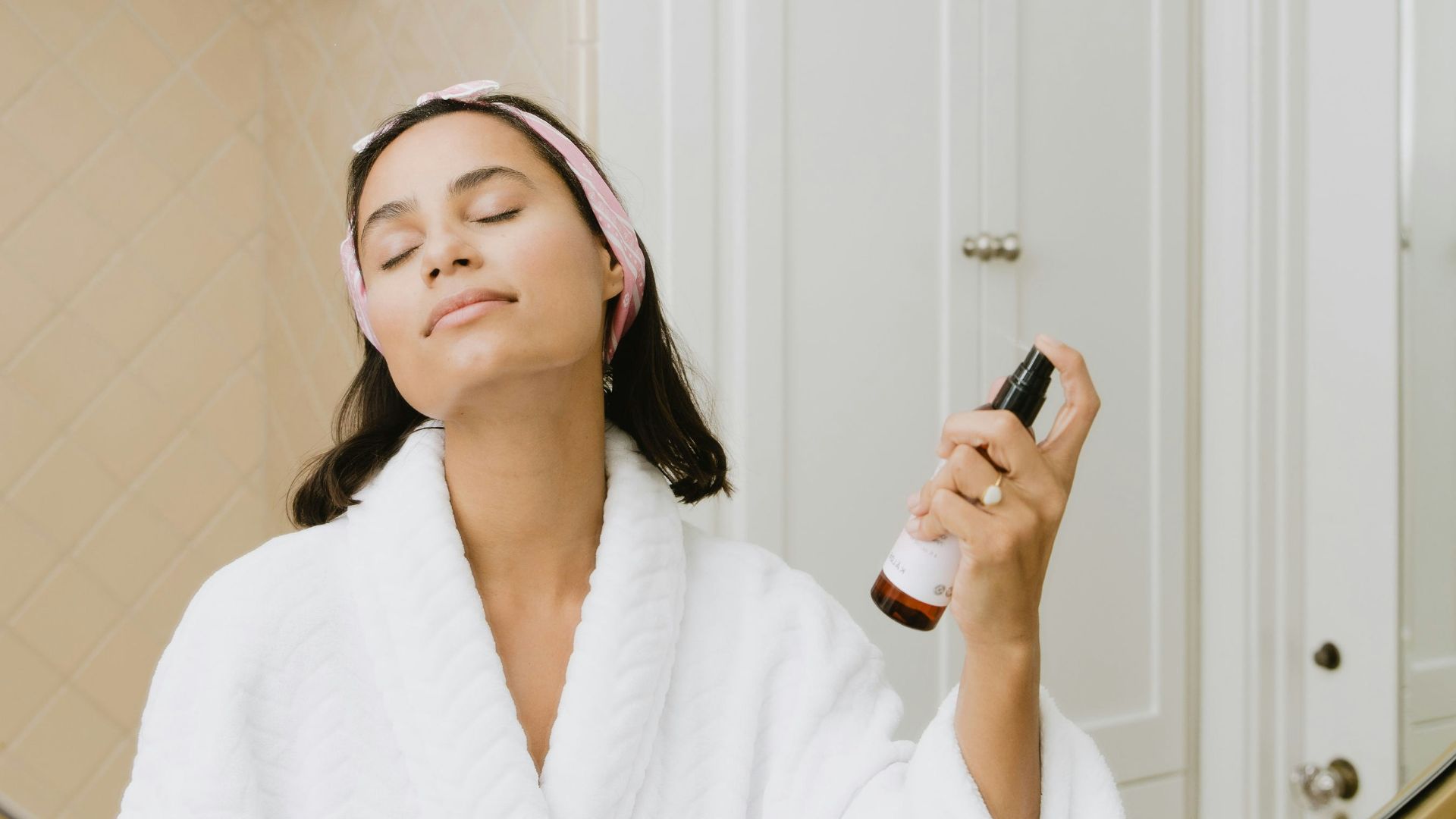 woman in white bathrobe holding smartphone