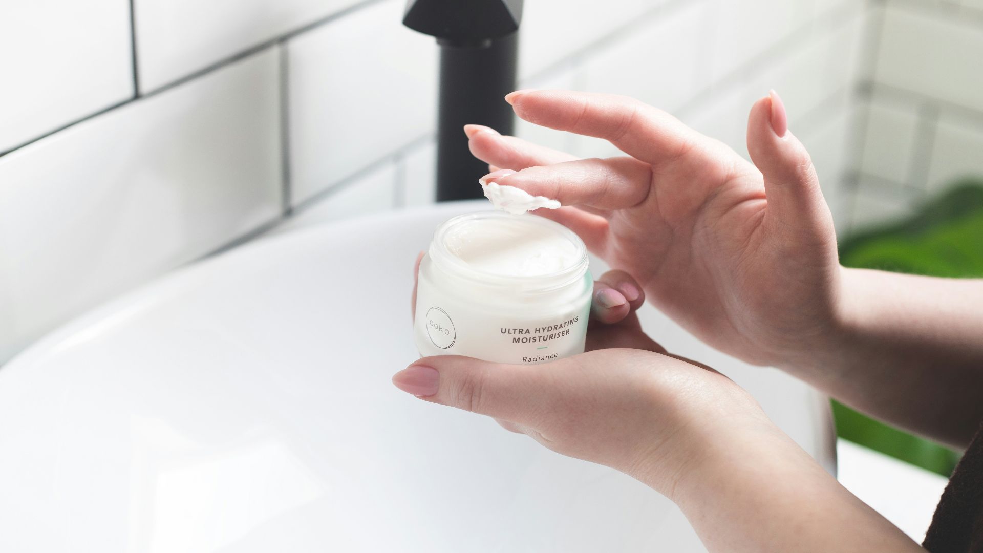 person holding white and black plastic bottle