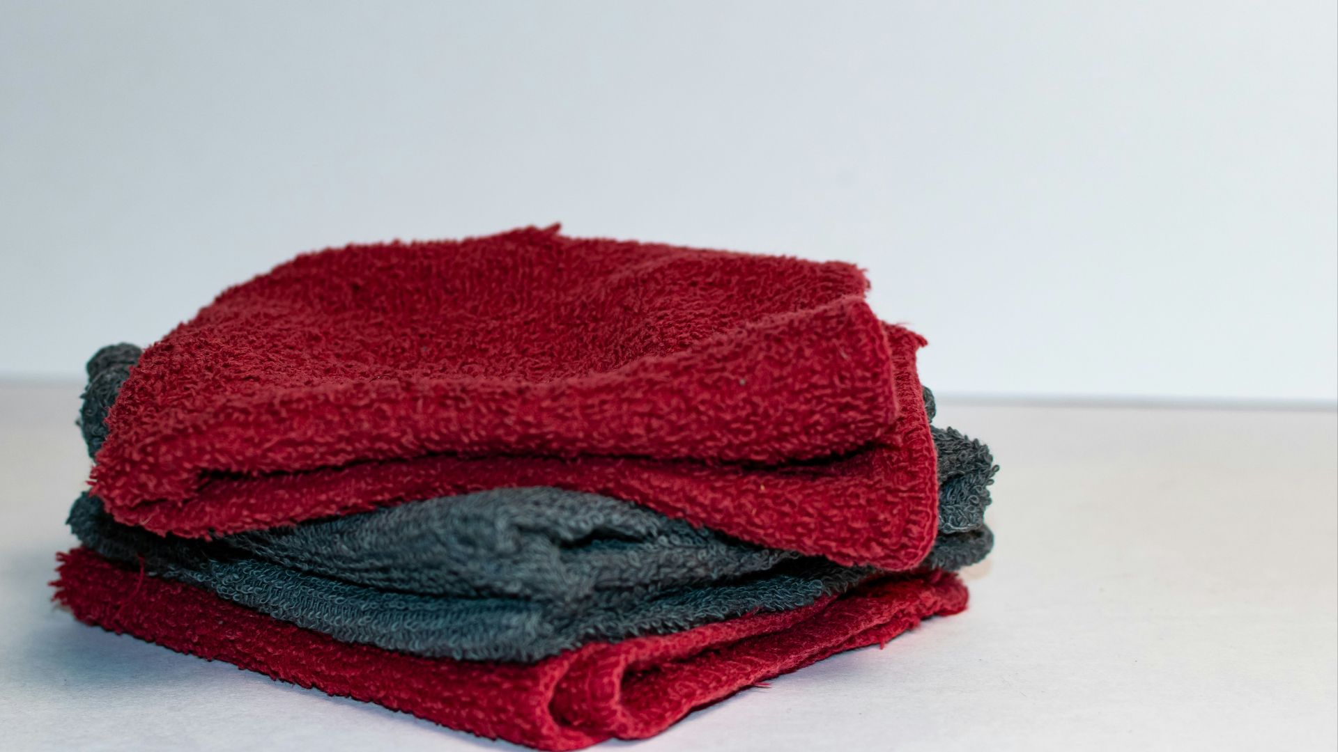 A stack of red and grey towels sitting on top of a table