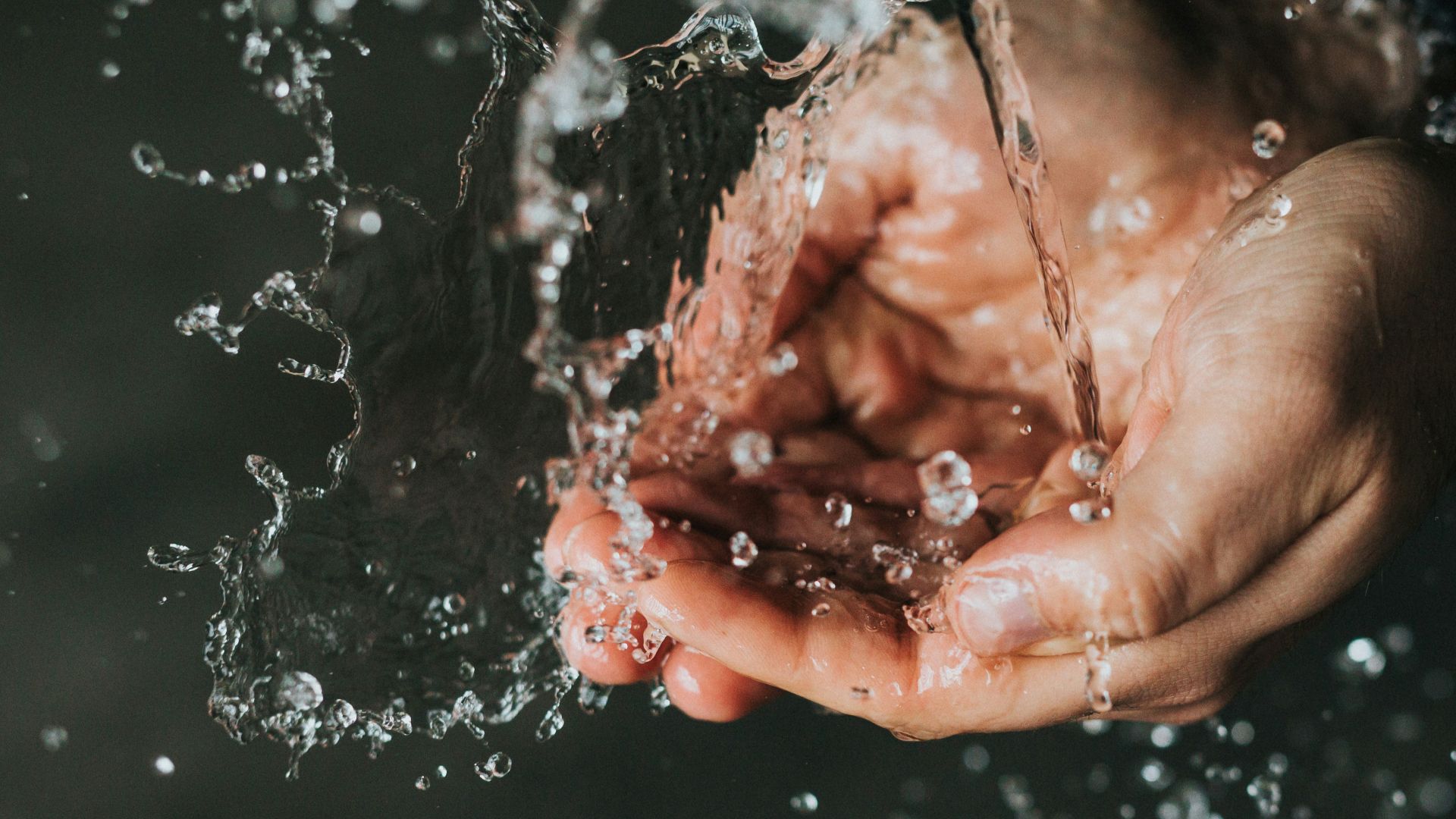 a person holding their hands under a stream of water