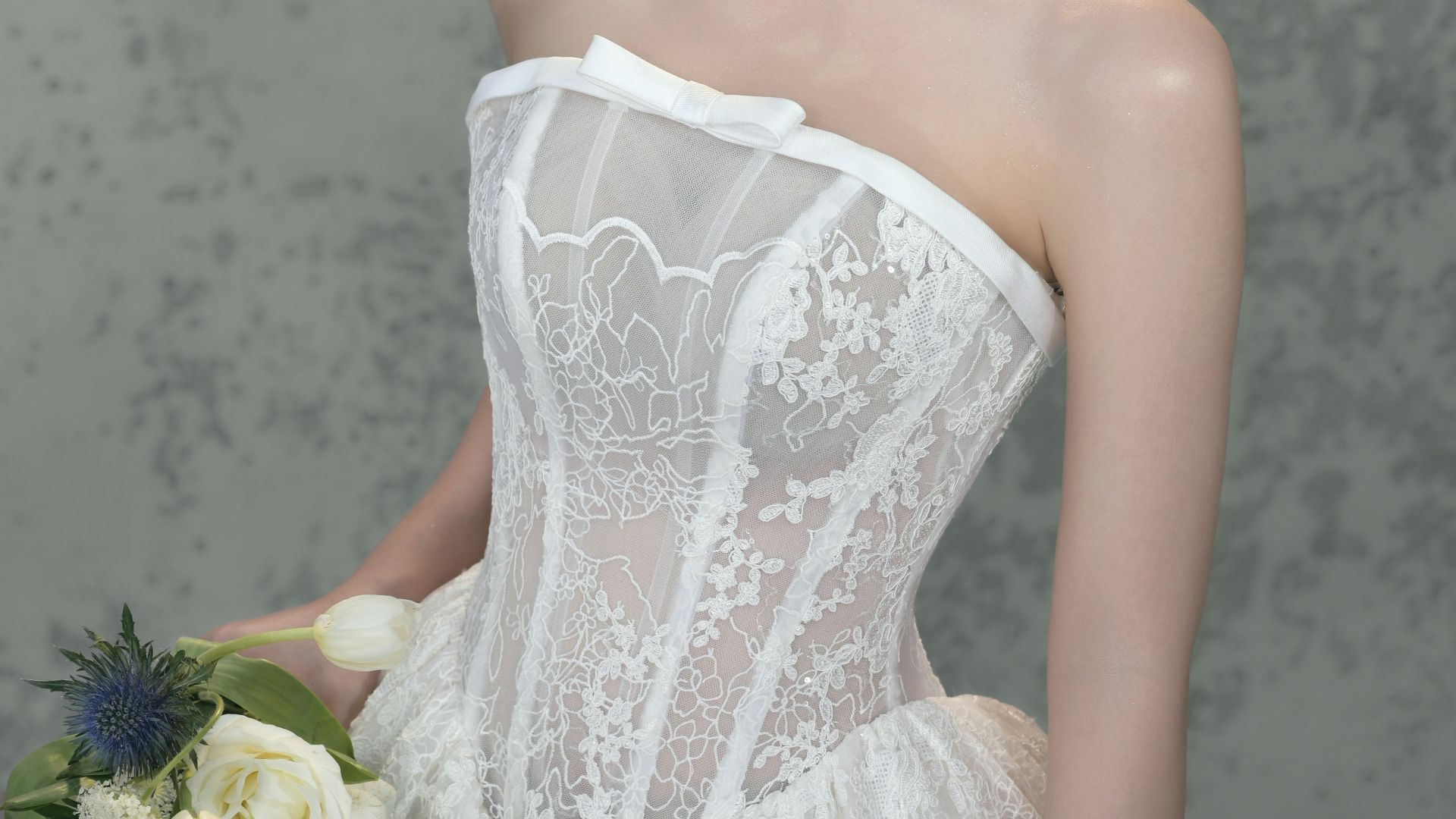 Bride in white lace dress holding a bouquet