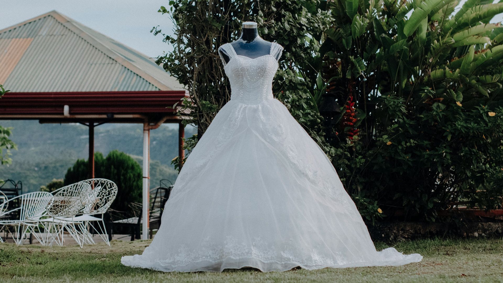a wedding dress on a mannequin in a garden