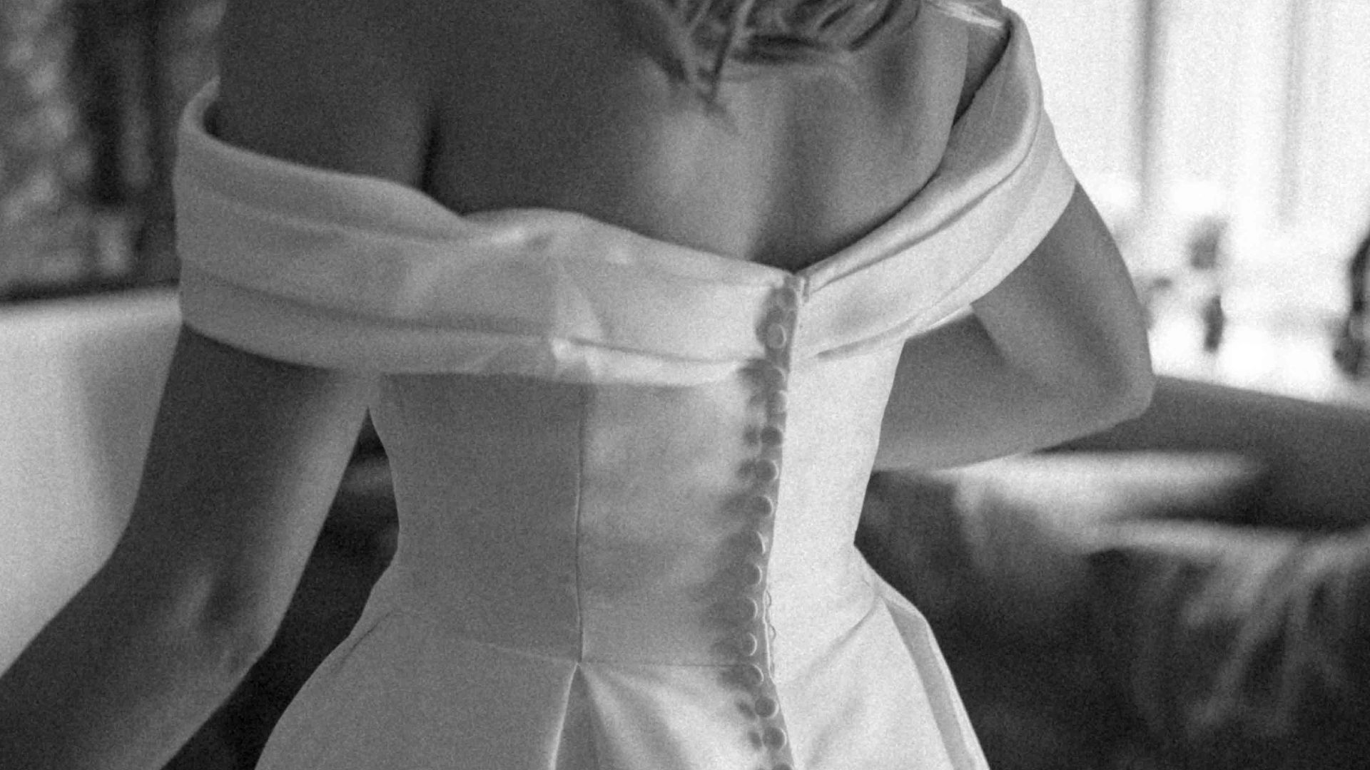 A woman in a wedding dress standing in a living room