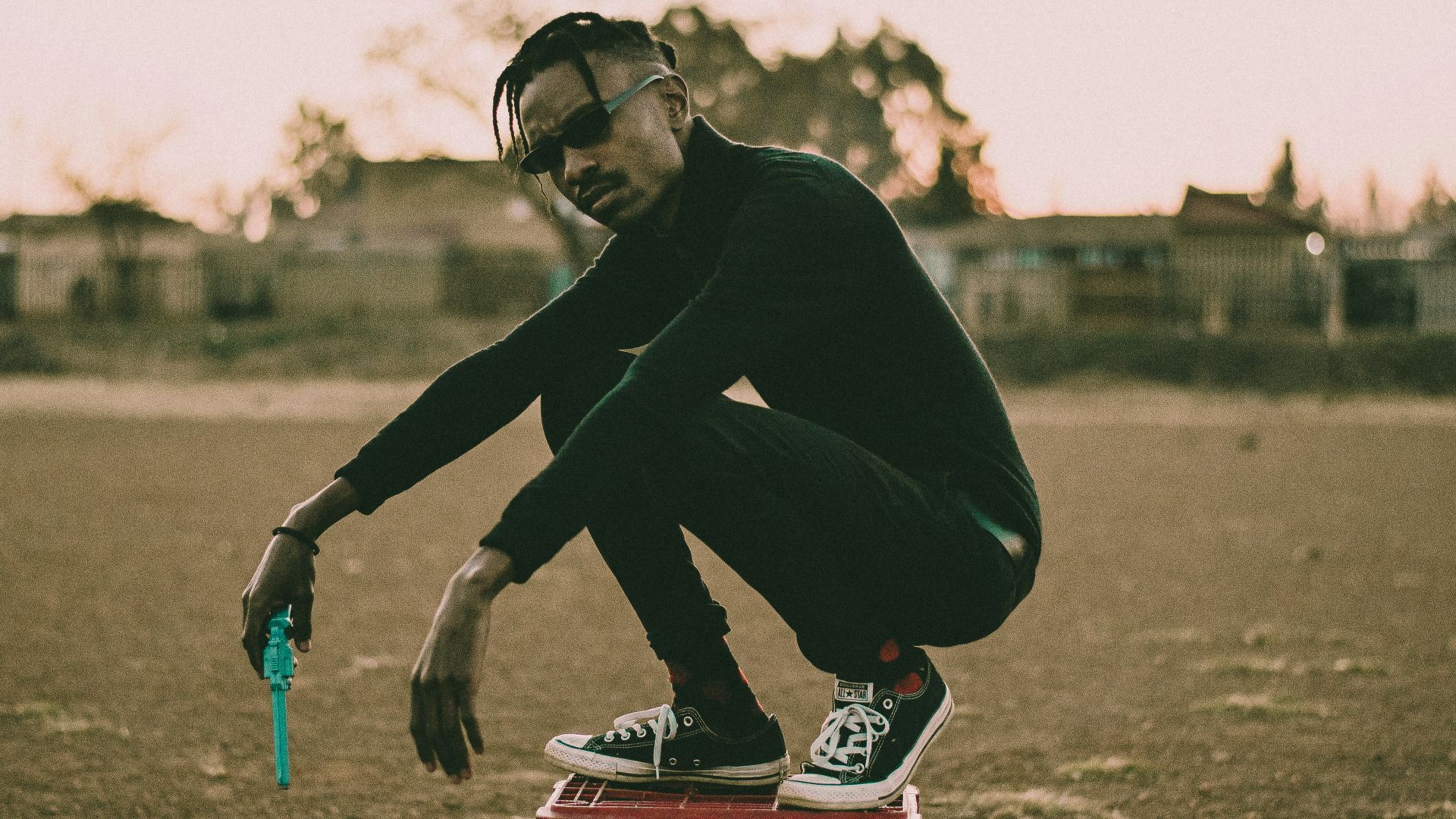 man in black hoodie and black pants sitting on red and black motorcycle during daytime