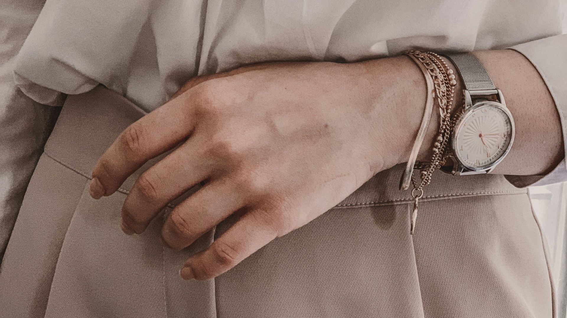 person in white dress shirt wearing silver link bracelet round analog watch