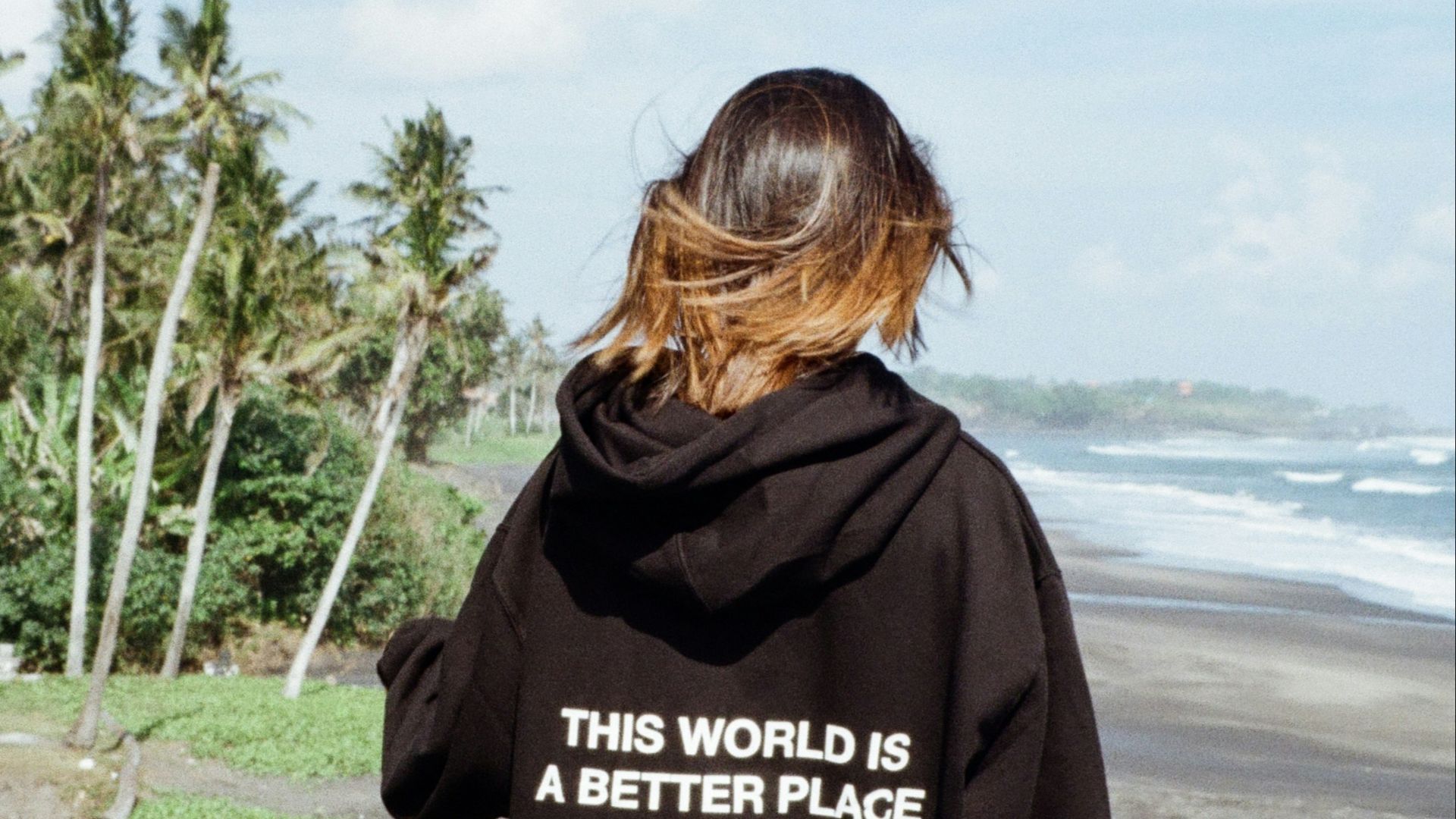 a woman in a black hoodie that says, this world is a better place