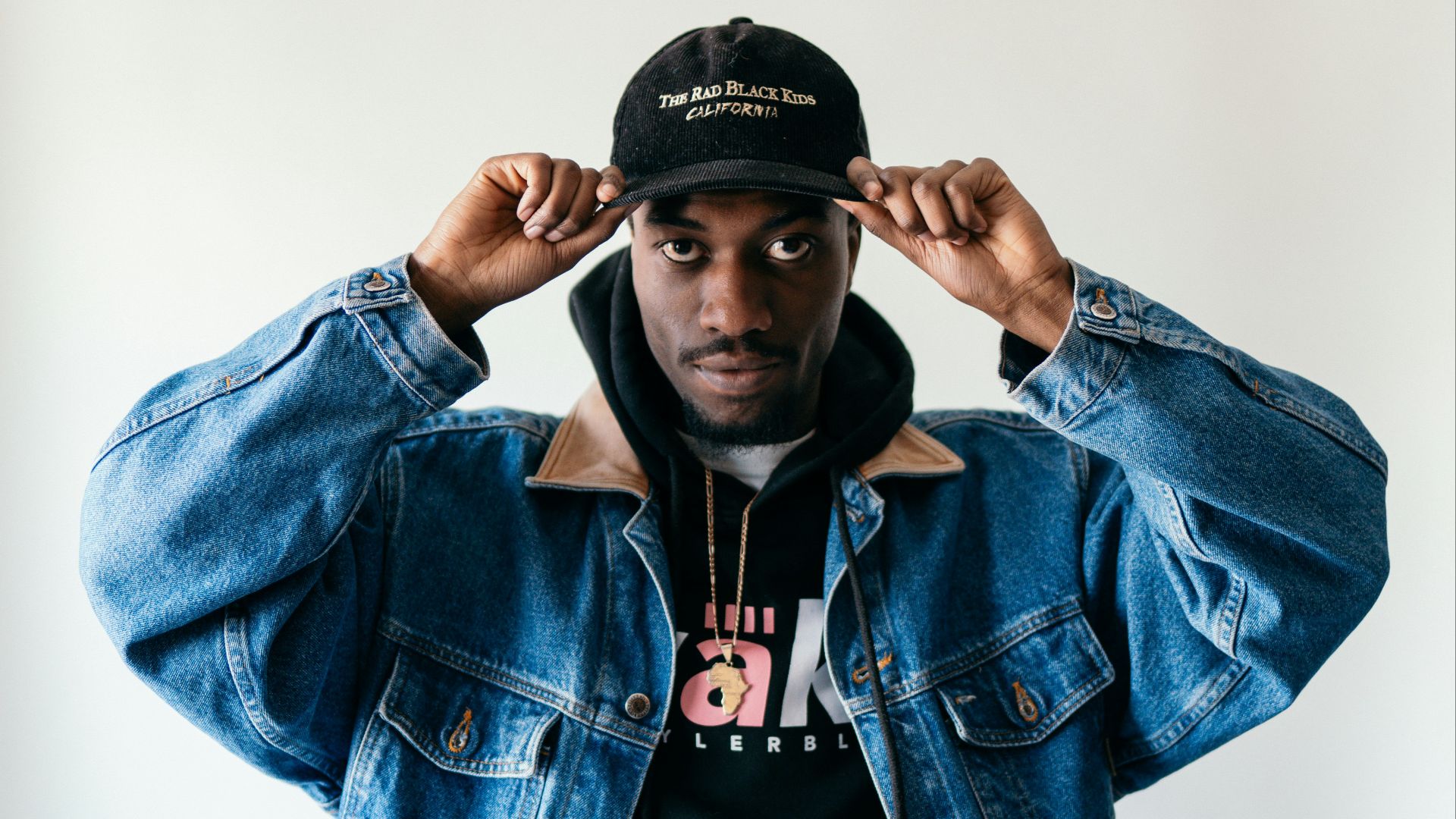 man in blue denim jacket and black fitted cap