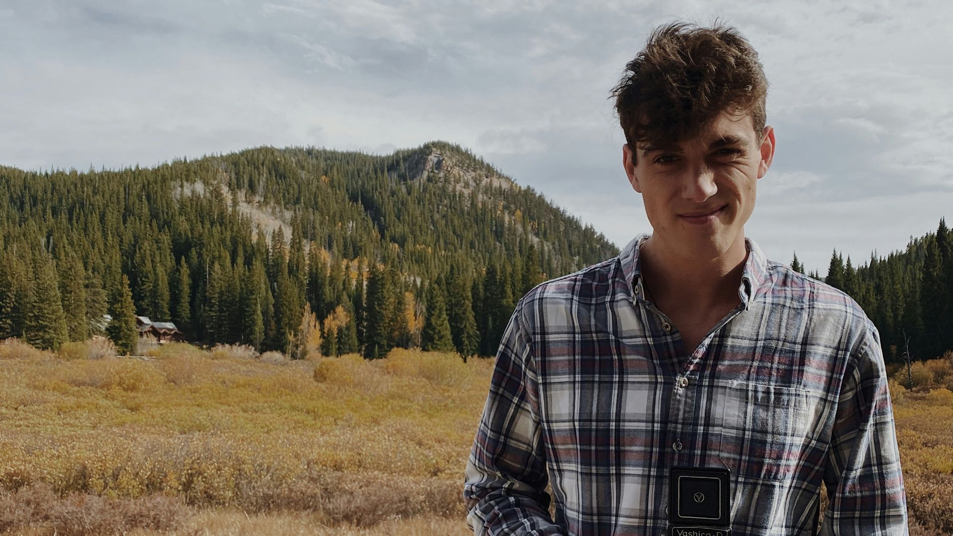 man in black and white plaid dress shirt standing on green grass field during daytime