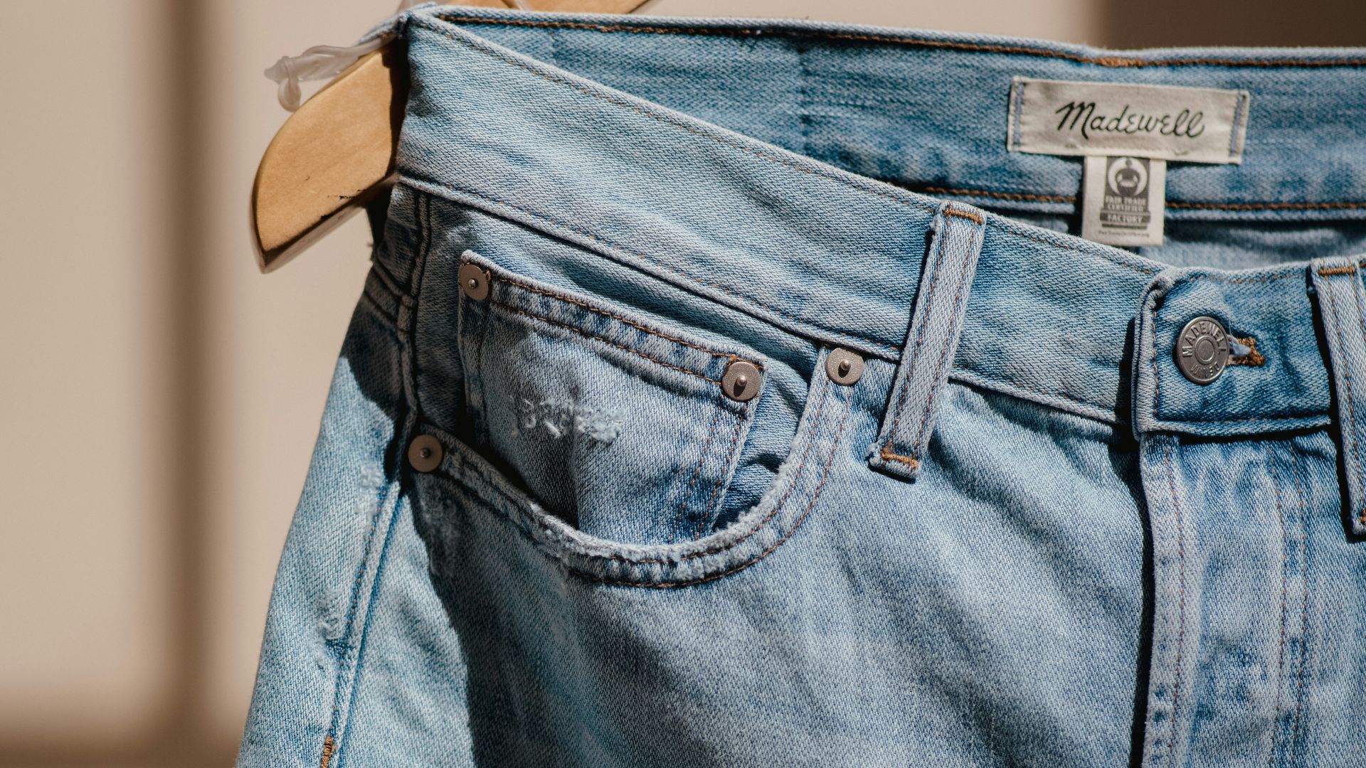 blue denim jeans on brown clothes hanger