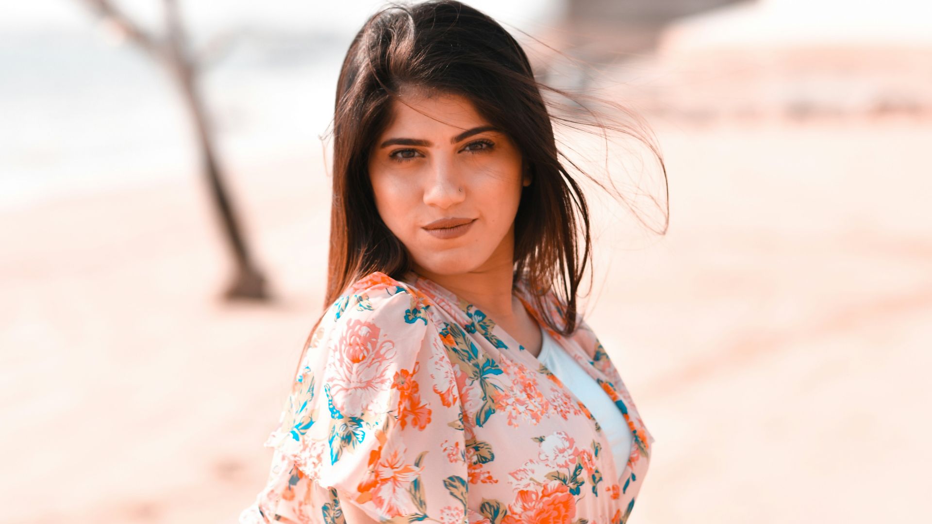 a woman in a floral dress poses for a picture