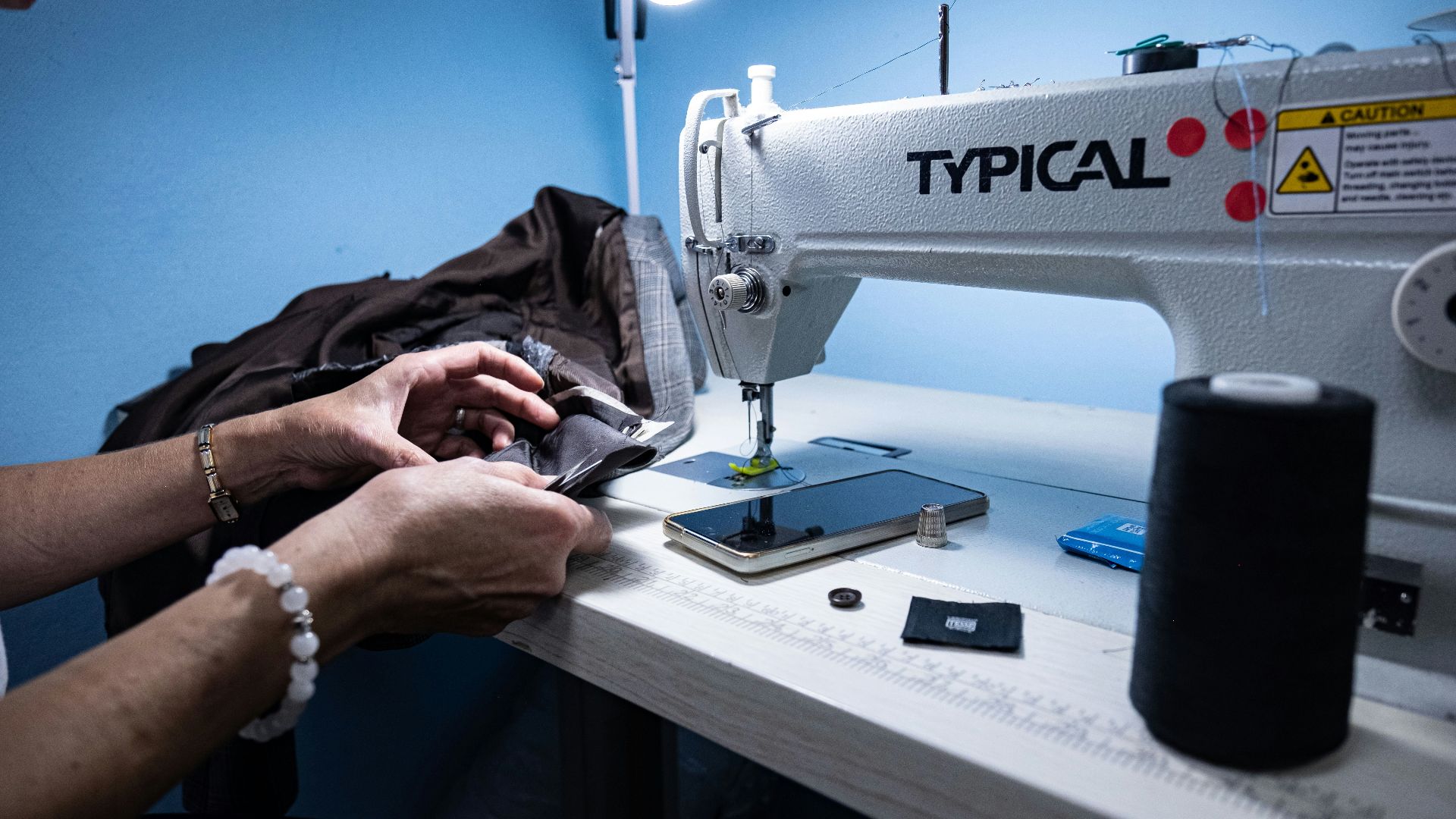 a woman is working on a sewing machine