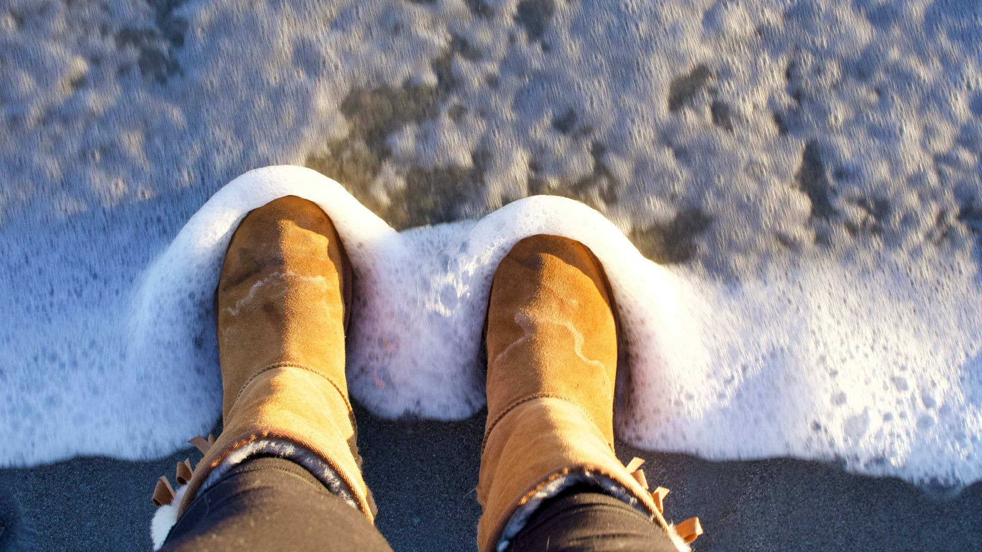 person in brown winter boots standing on snow covered ground