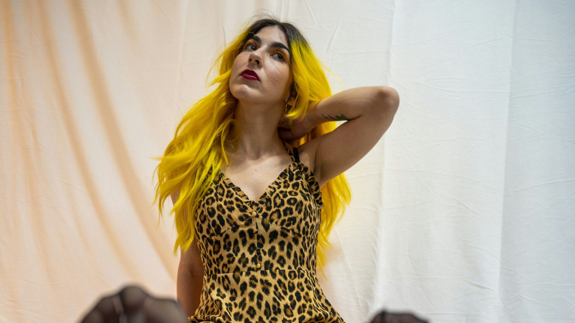 a woman sitting on a bed with her legs up