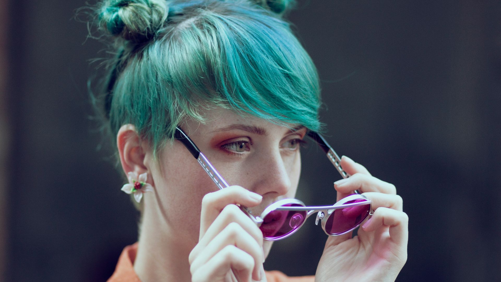 A woman with green hair is talking on a cell phone