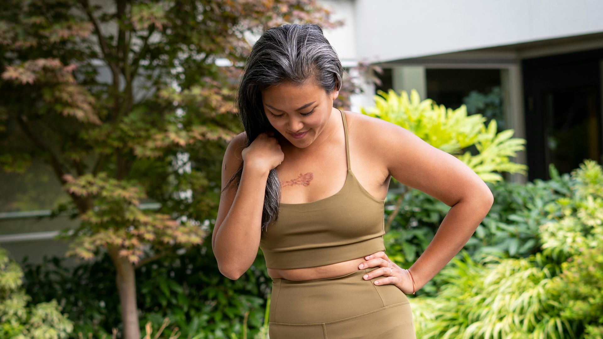 woman in brown bra and brown pants standing on gray concrete pathway during daytime