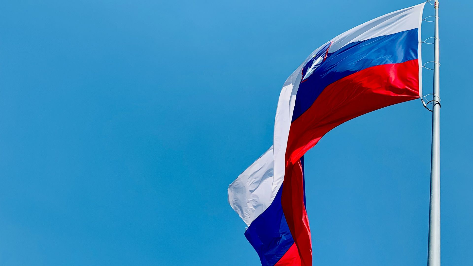 A red, white and blue flag flying in the wind