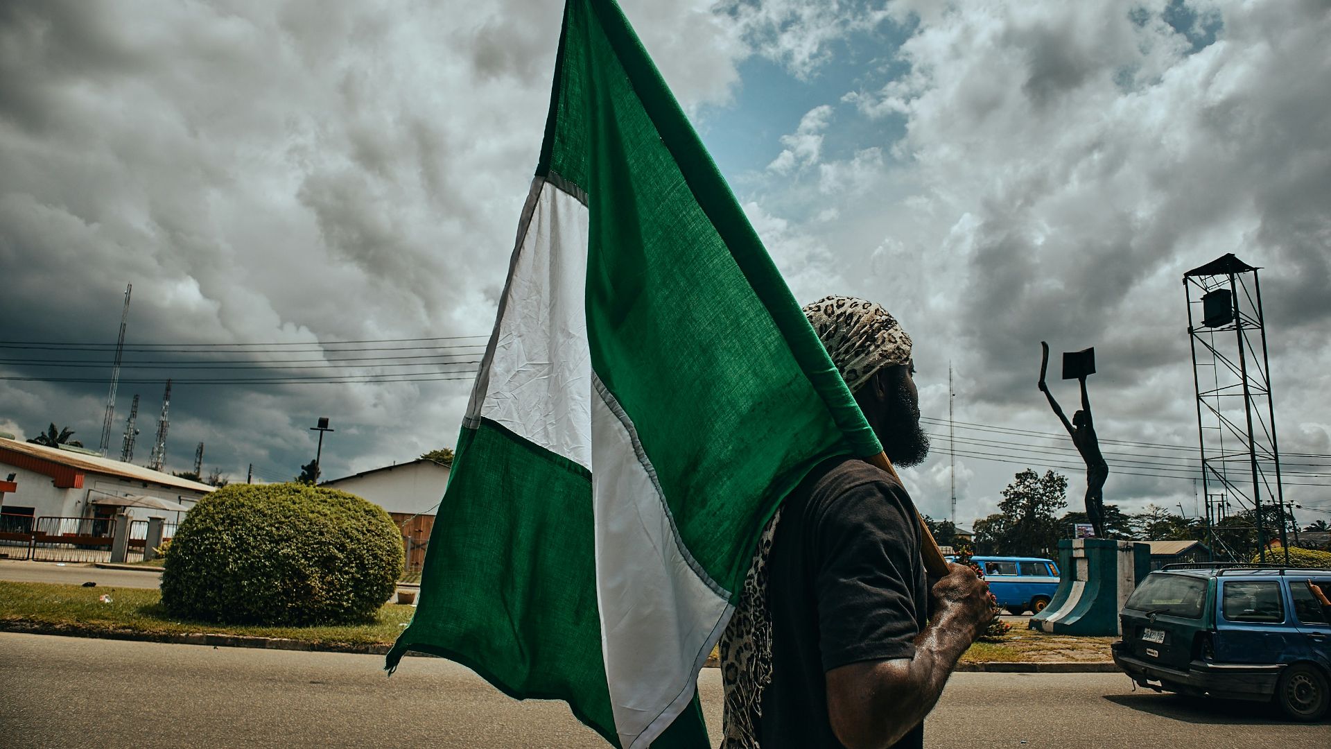 woman in black and white hijab holding green flag