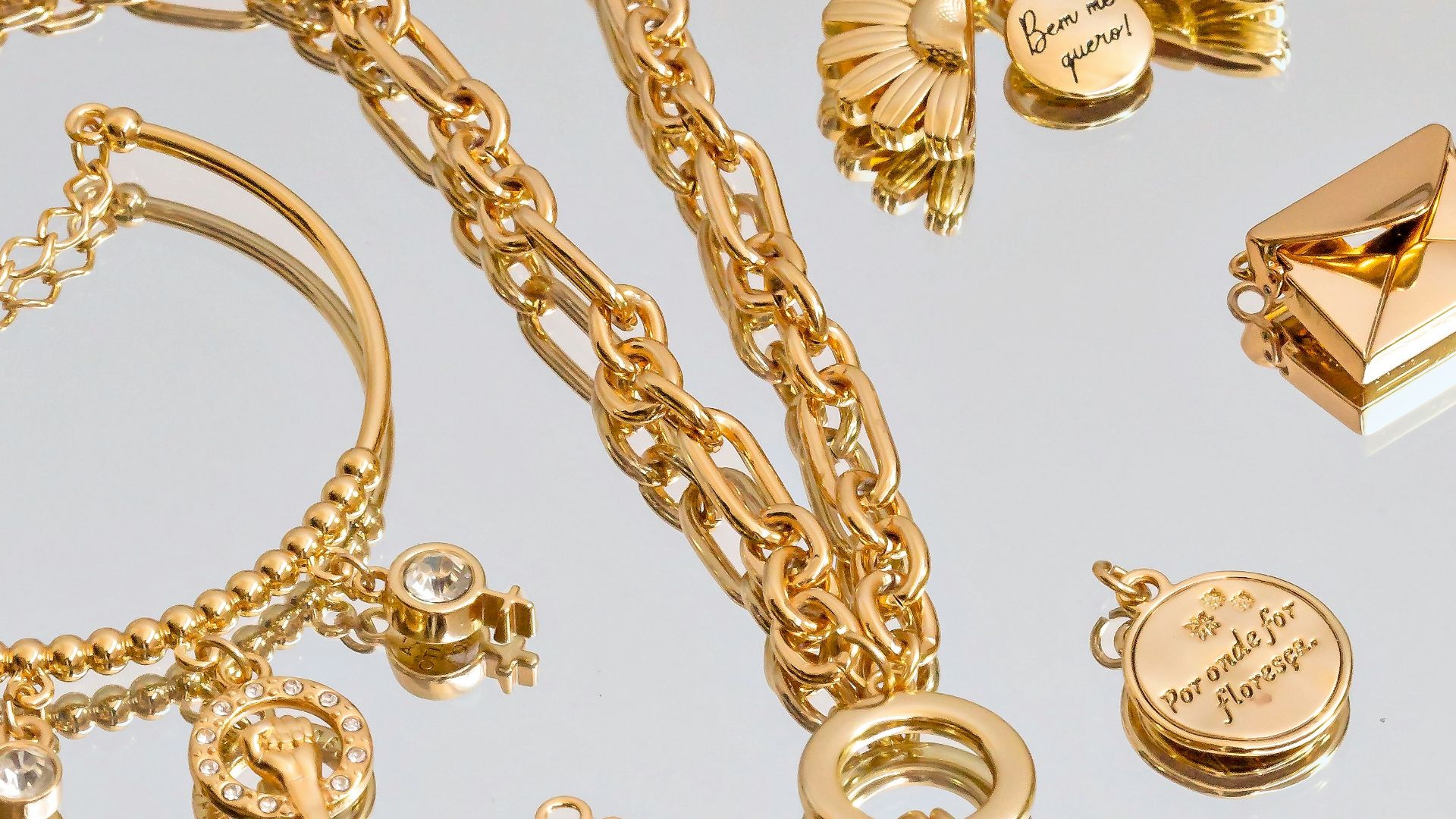 a silver tray topped with lots of gold jewelry