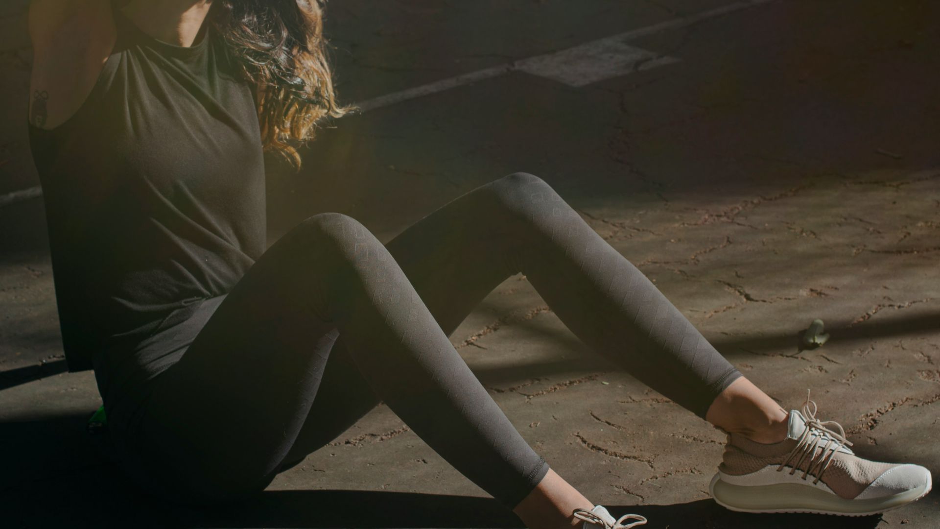 a woman sitting on the ground with her legs crossed