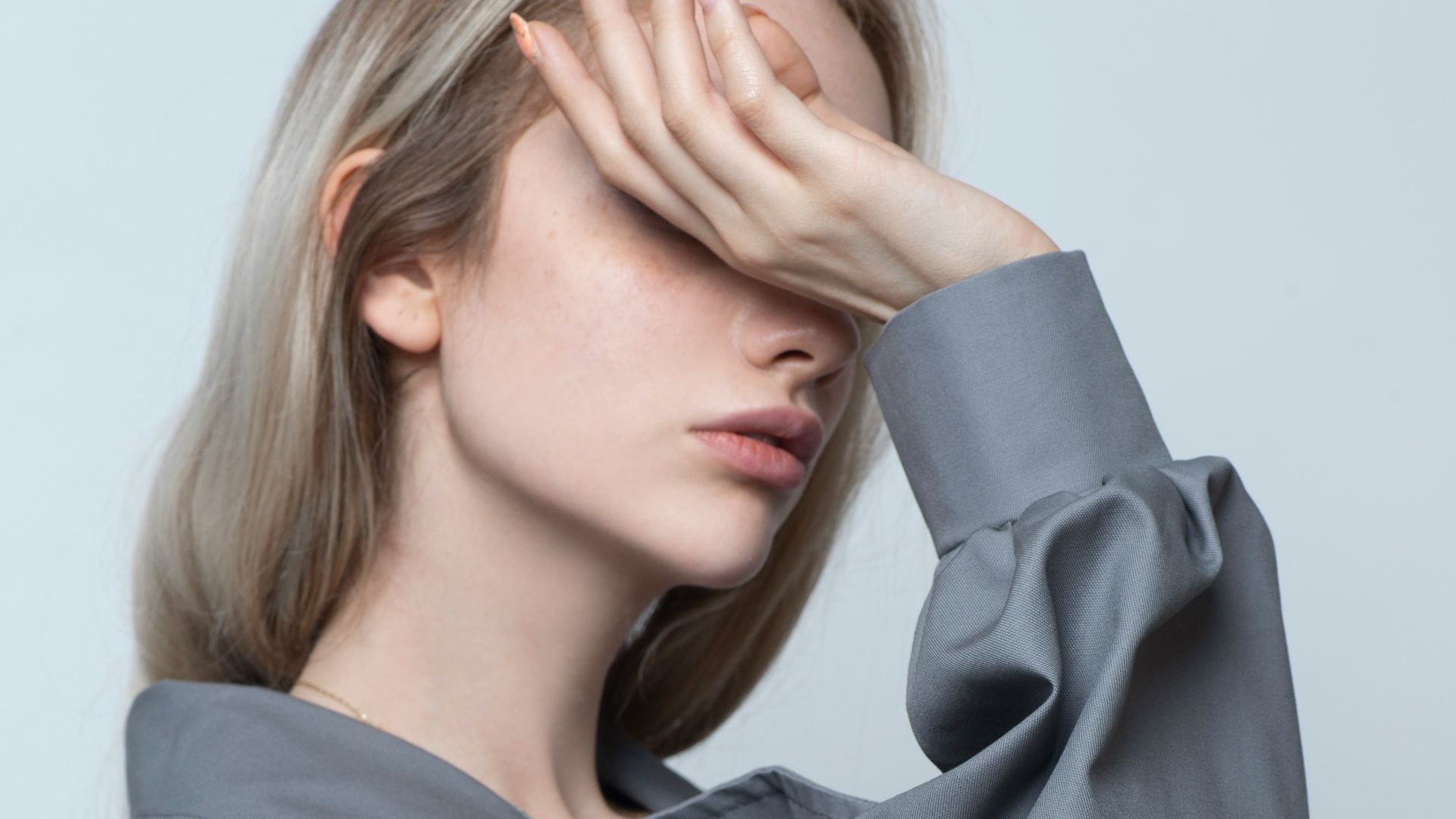 woman in black long sleeve shirt covering her face