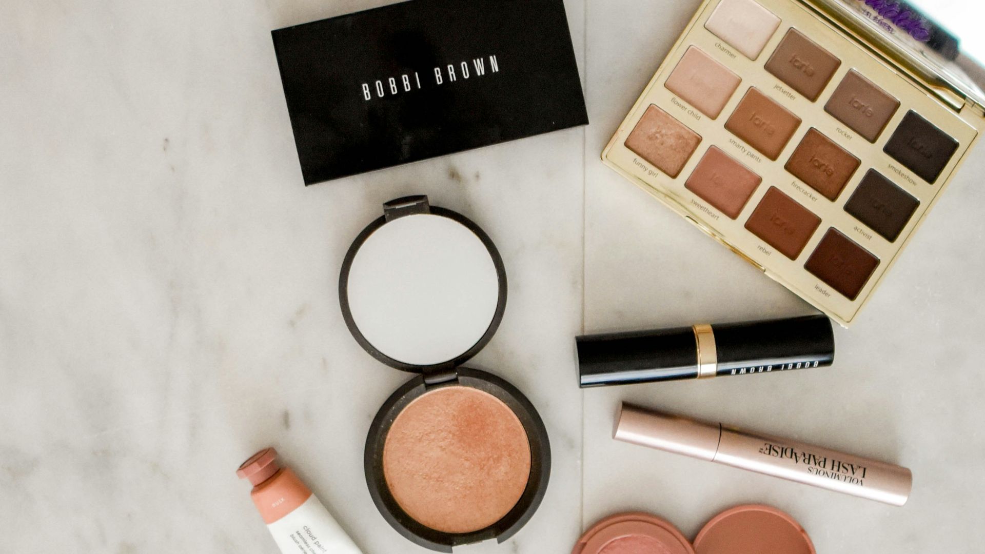 photo of assorted makeup products on gray surface