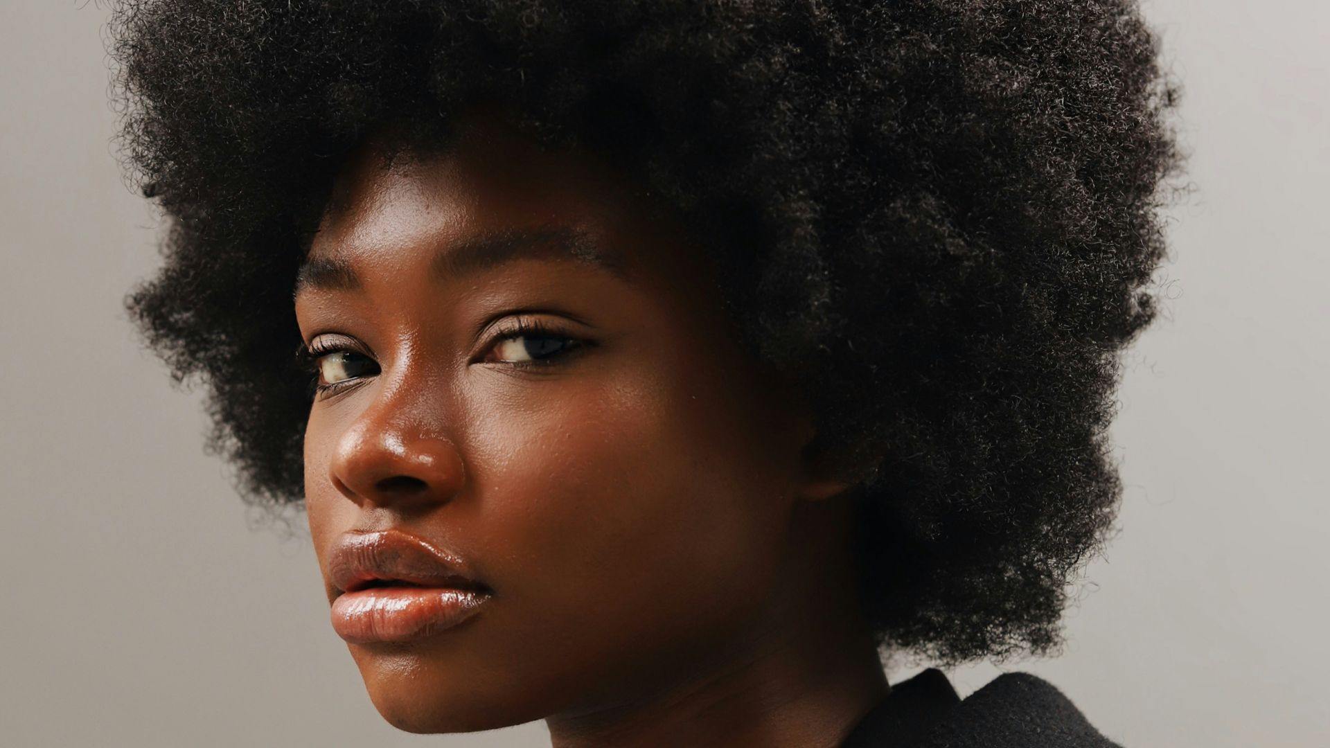 a woman with an afro is looking at the camera