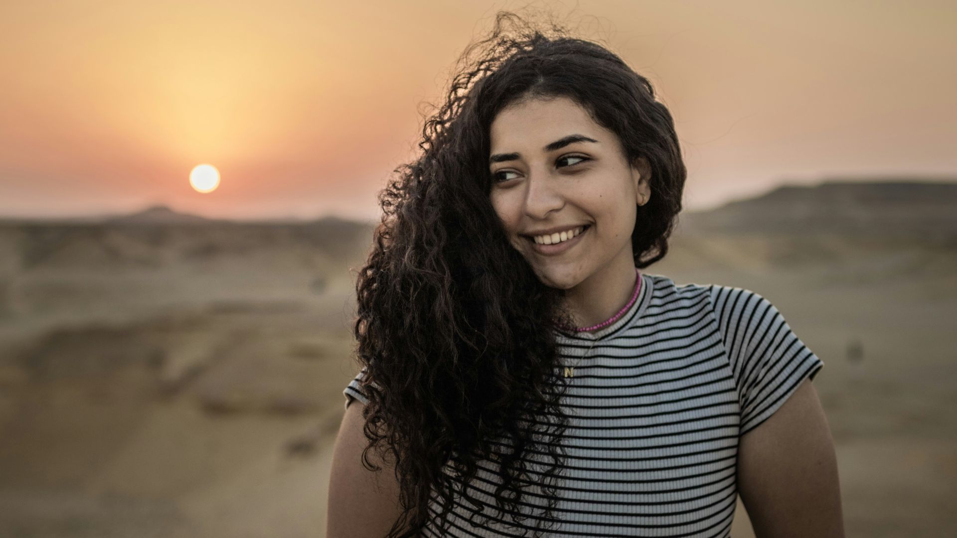 a woman standing in the middle of a desert