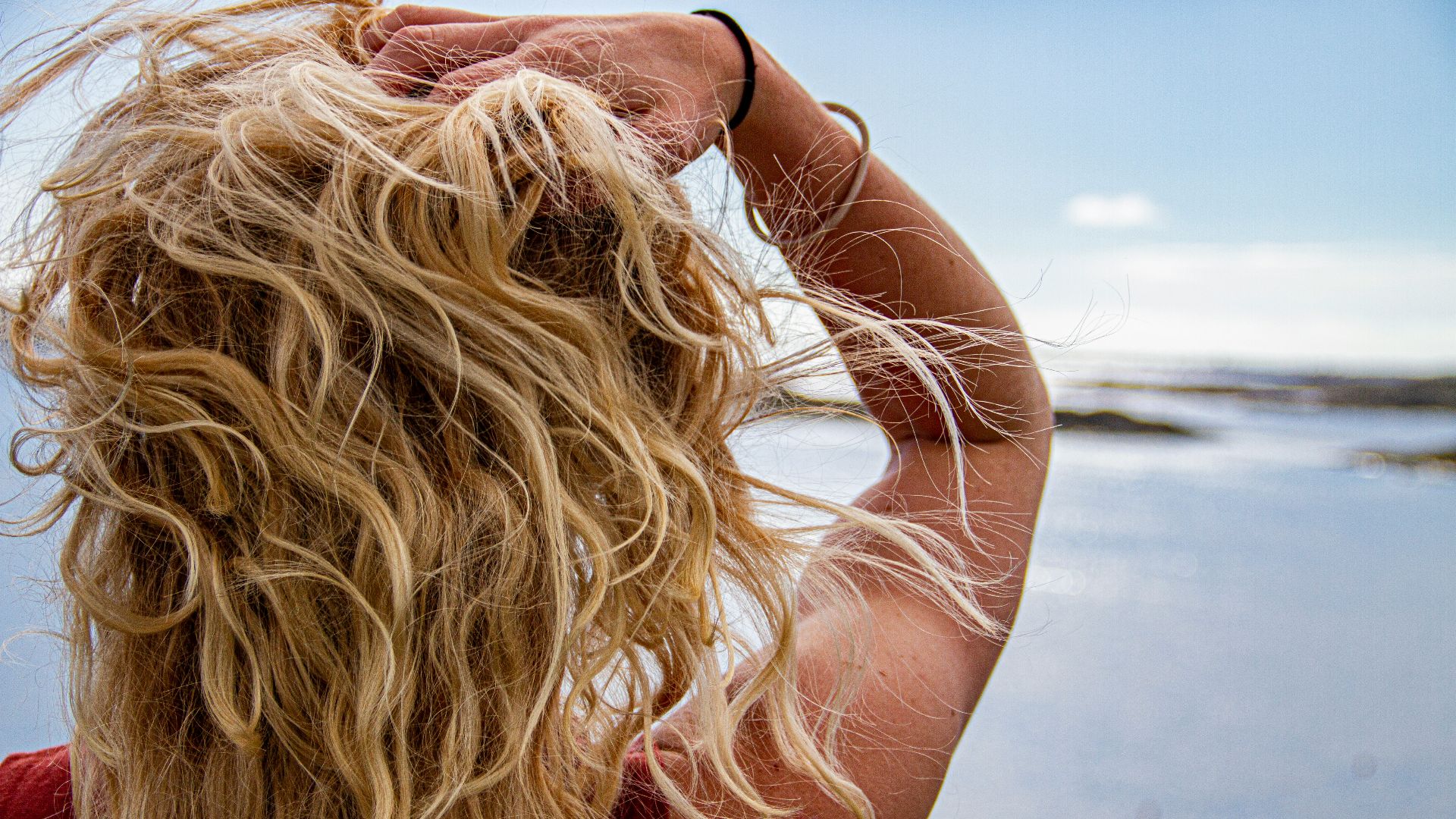 woman in black sunglasses covering her face with her hair