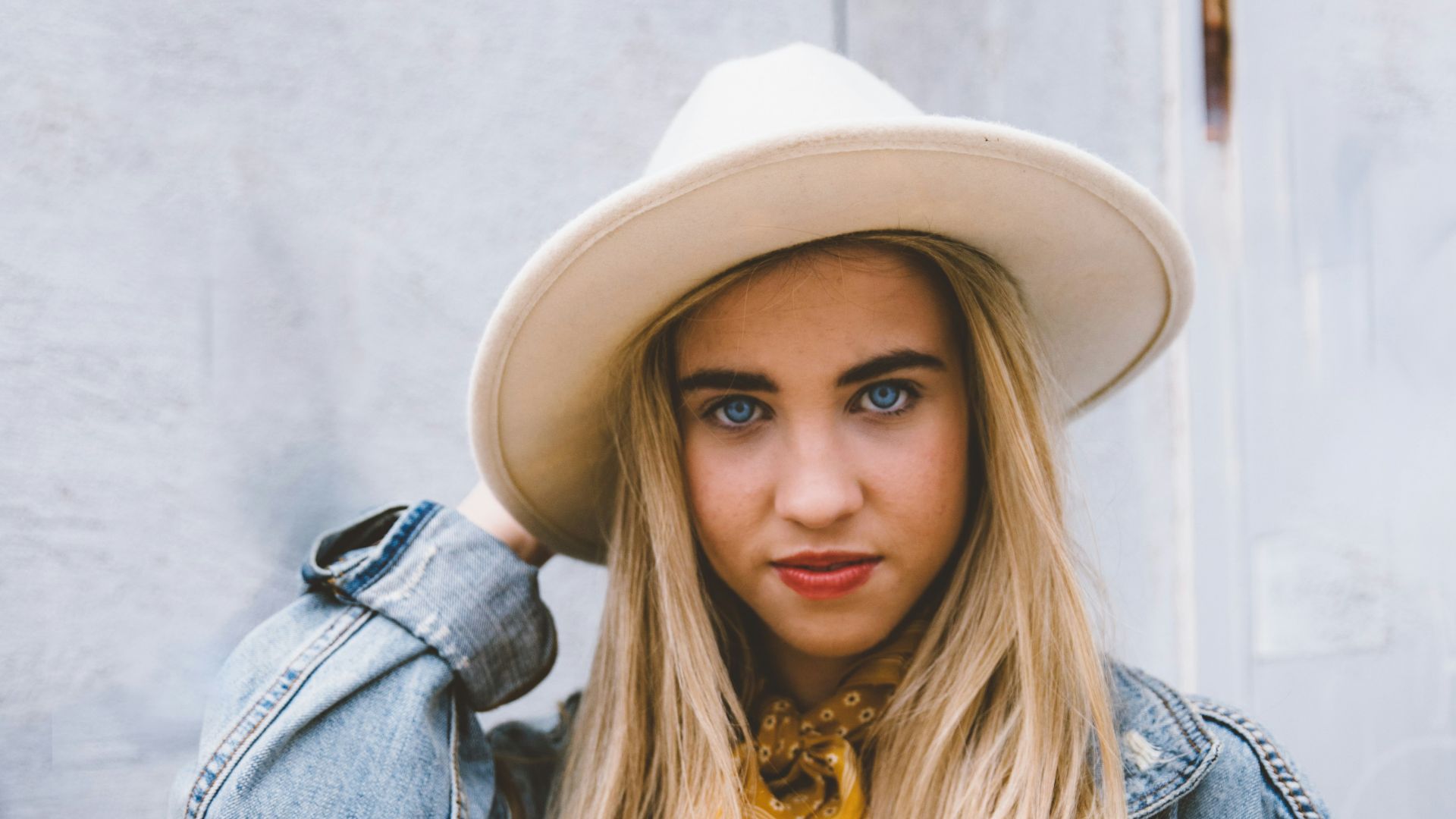 woman wearing blue denim jacket and white hat