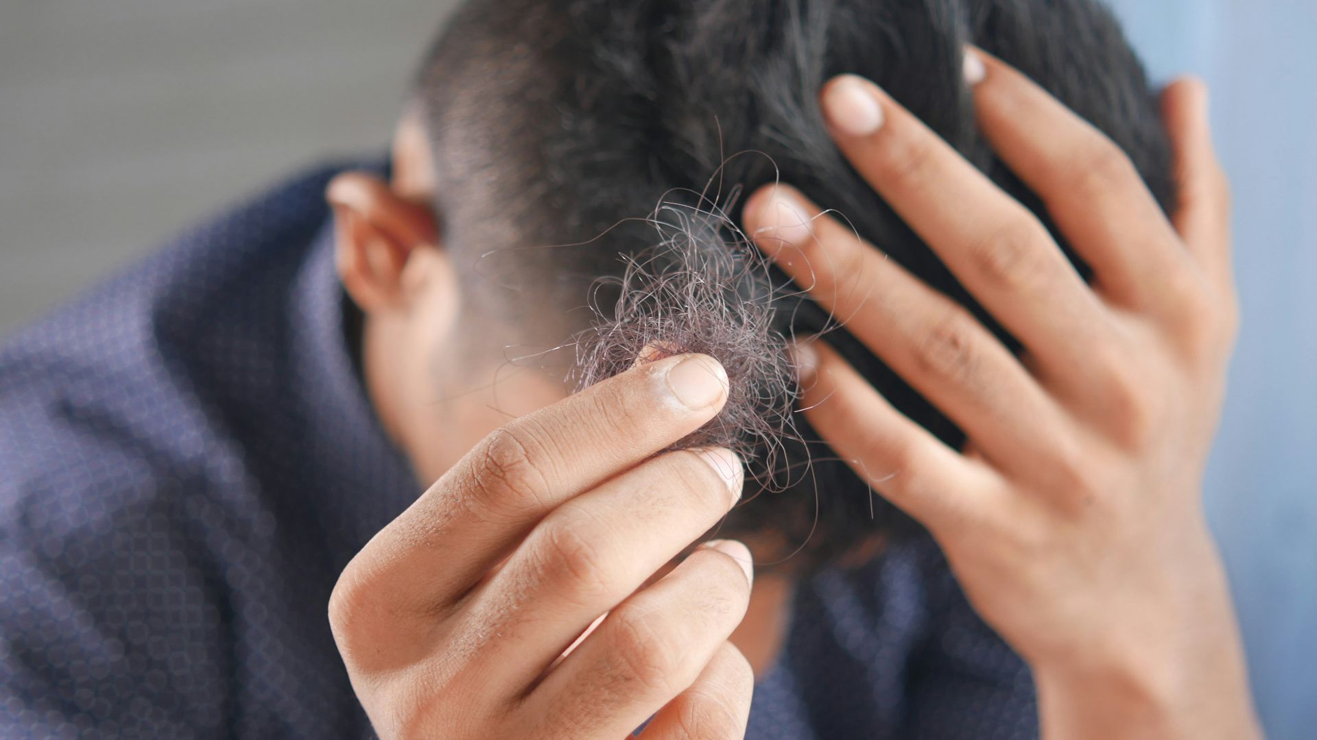 a man is combing his hair with his hands