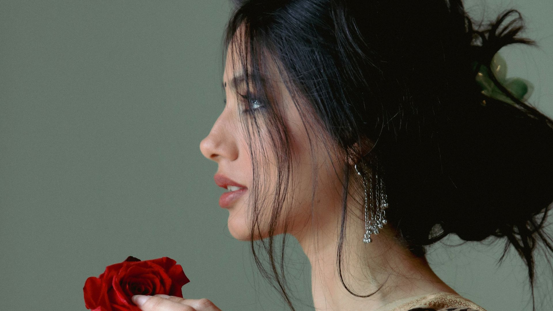 A woman is holding a rose in her hand