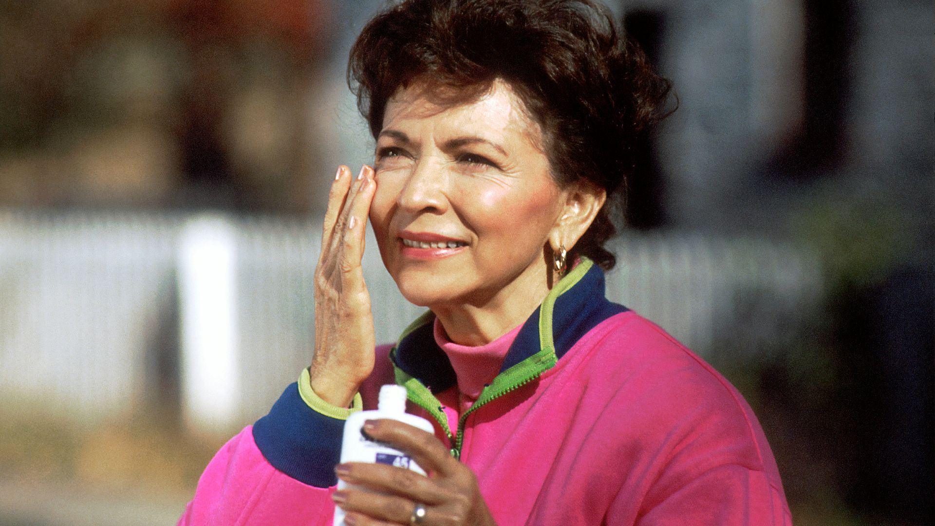 smiling woman in pink and blue shirt