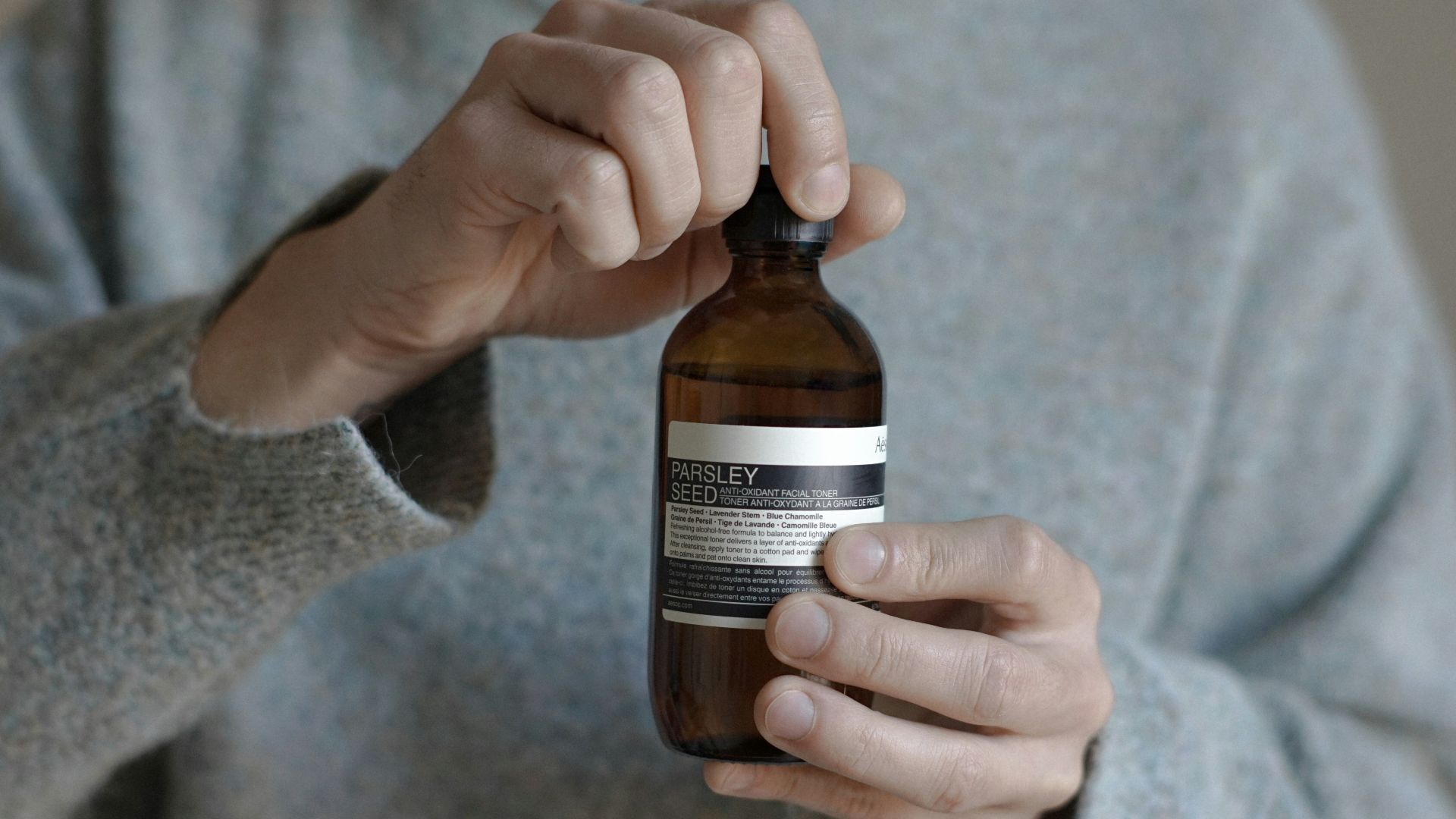 a person holding a bottle of beer in their hand