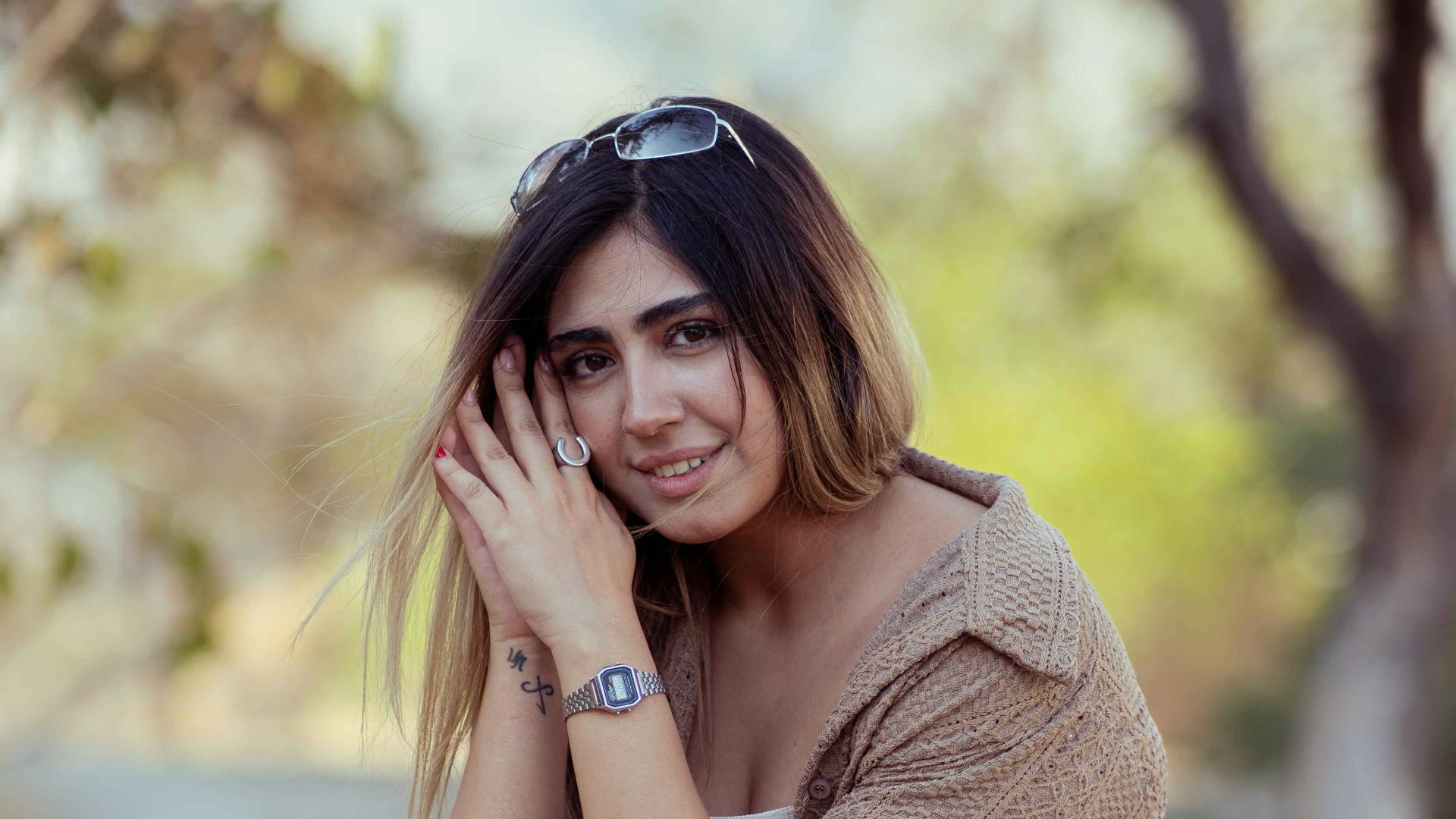 A young woman sitting outdoors on a rock.