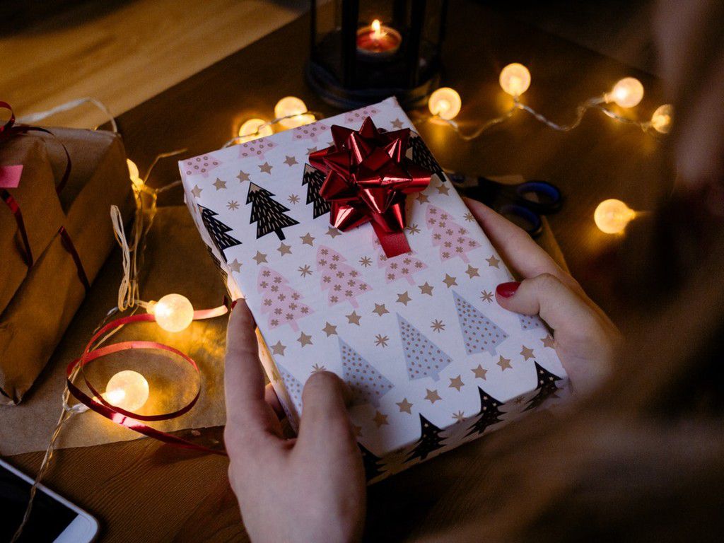 person-holding-gift-box-with-red-ribbon-beside-string-lights-1687049pexels.jpg.optimal.jpg