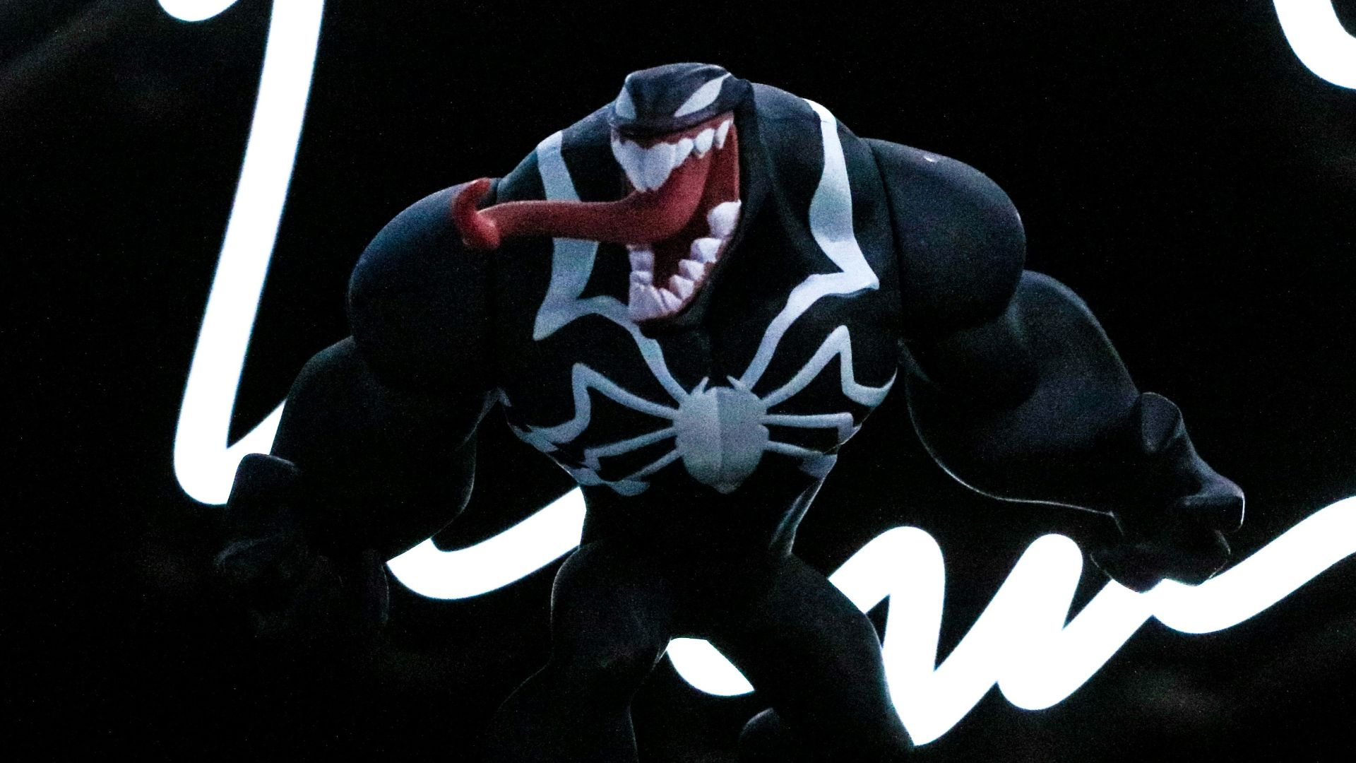 a spider - man figure is posed in front of a neon sign