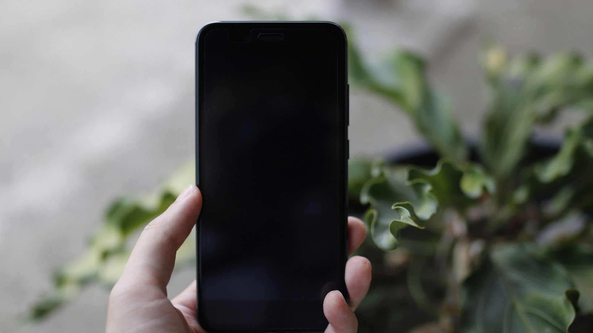 person holding turned off black smartphone