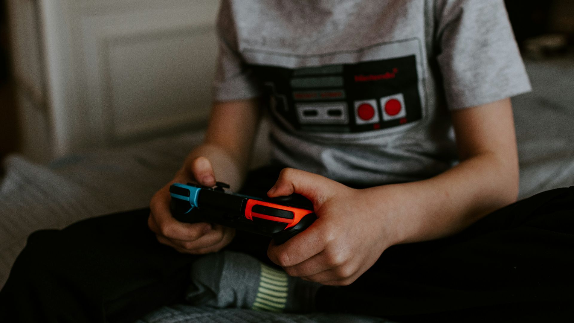 kid sitting on gray bed while playing