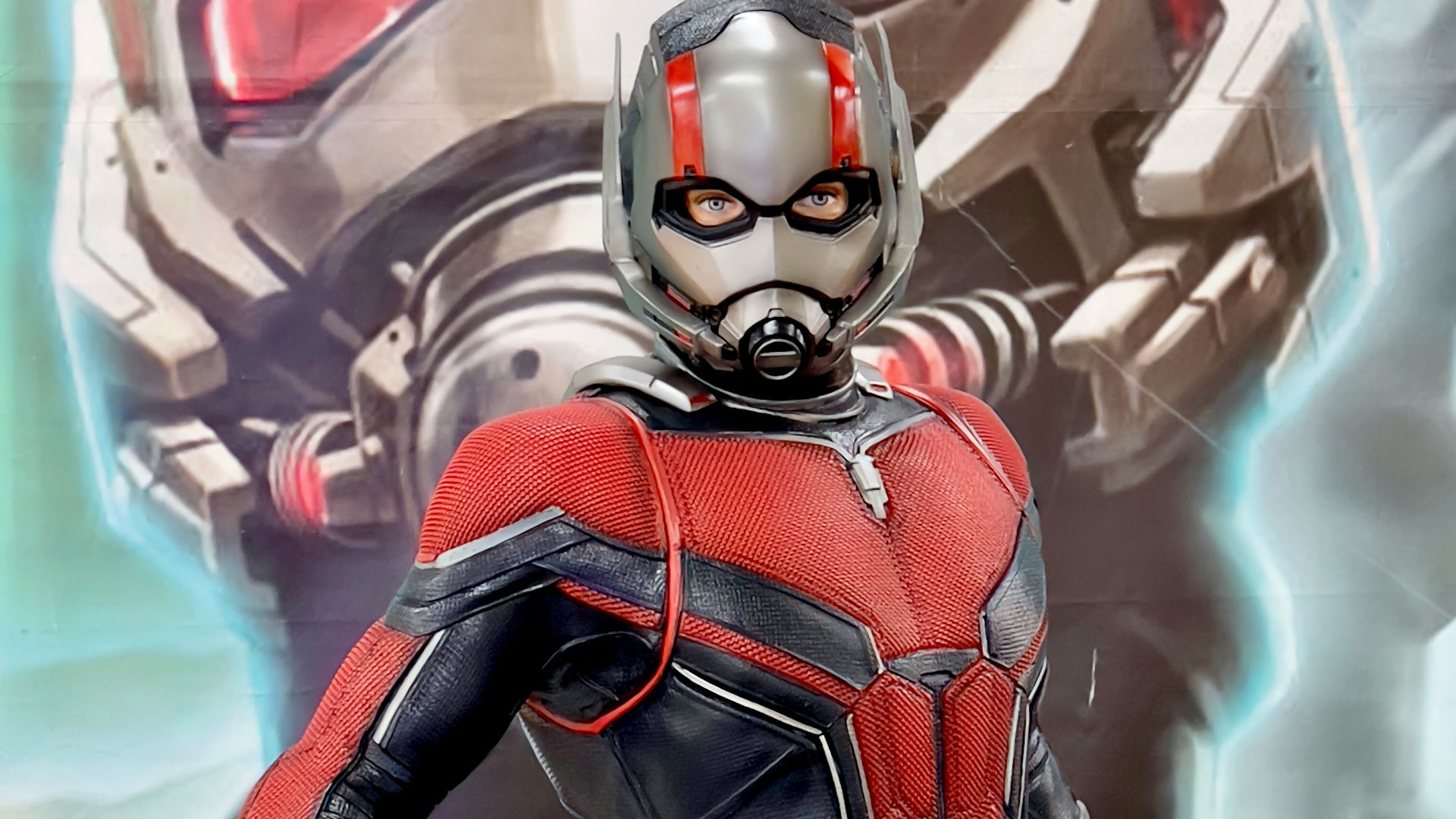 a man in a red and black suit standing next to a giant robot