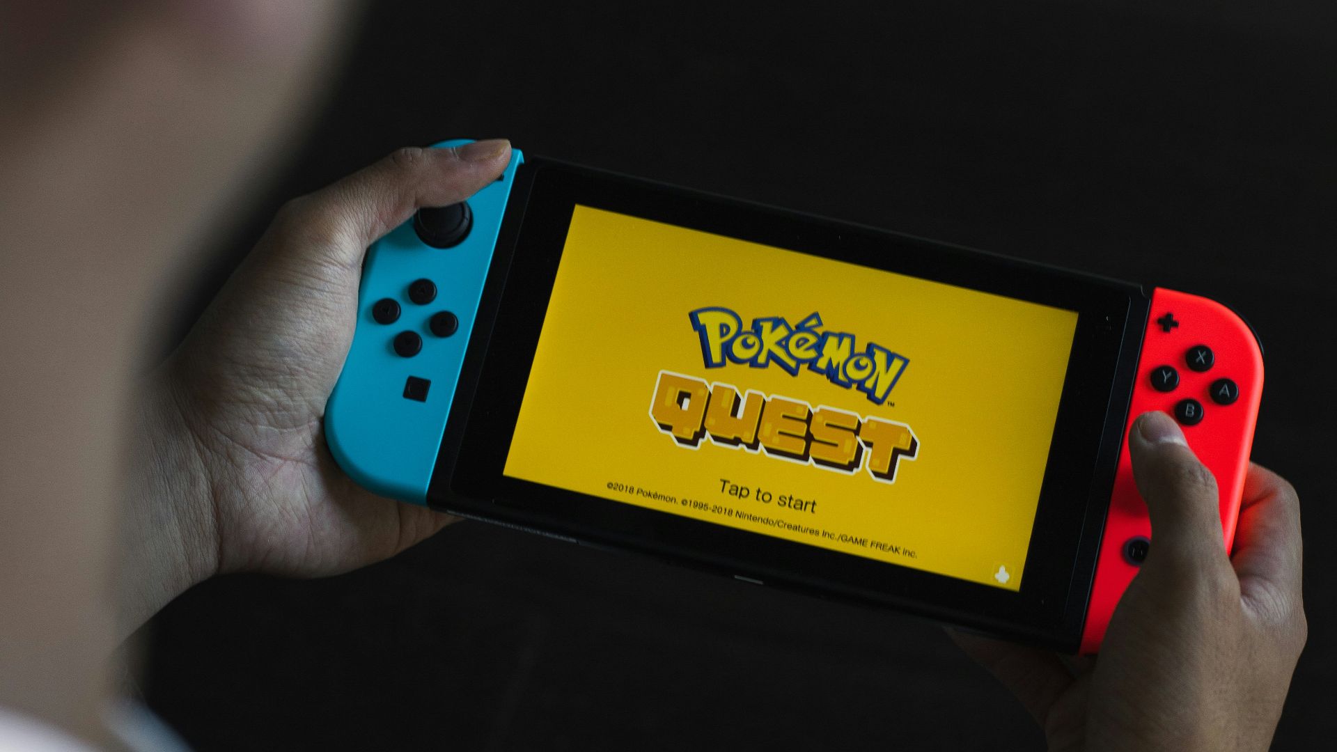 person holding yellow and blue box