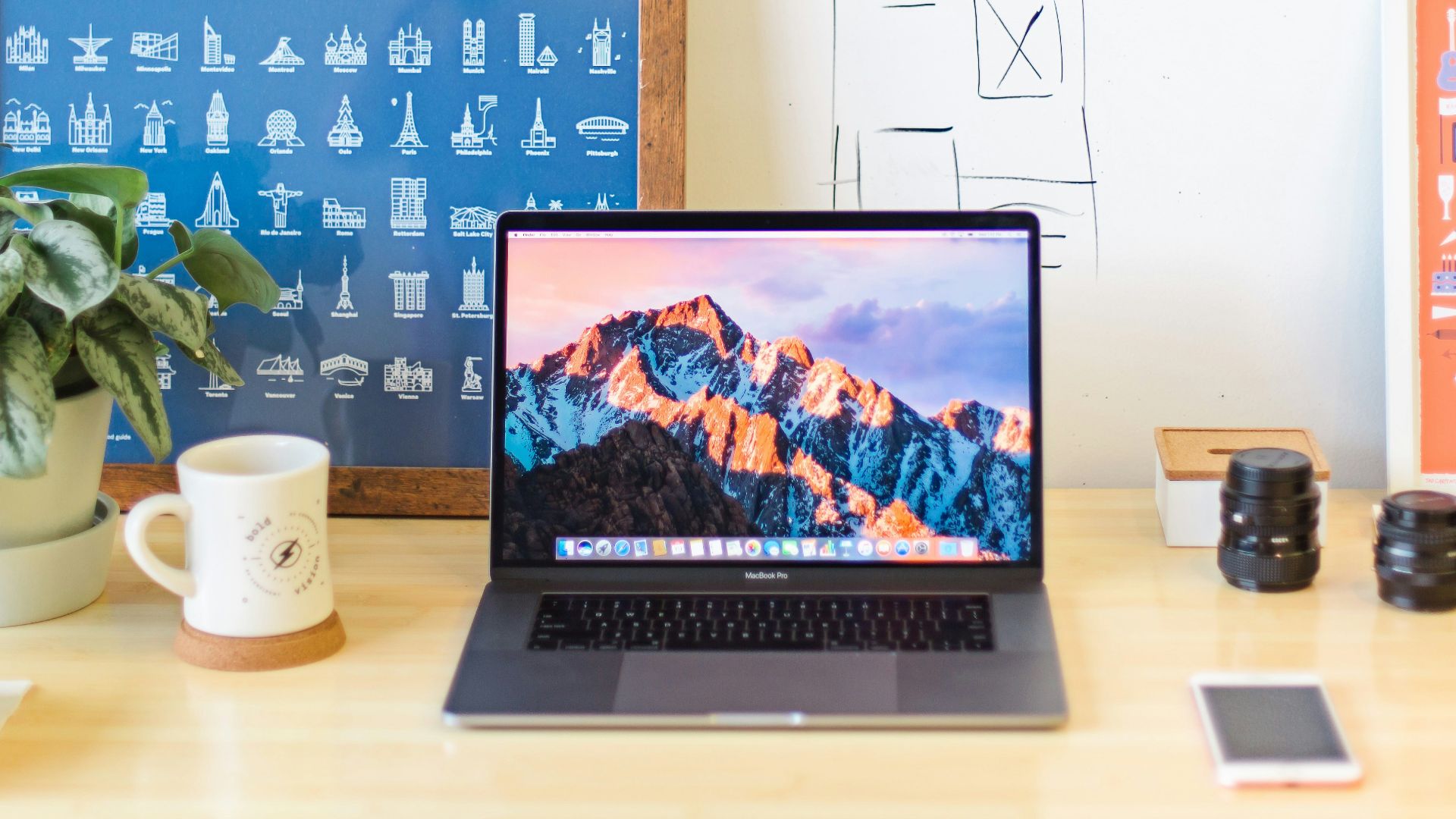 MacBook Pro on brown wooden table beside white mug