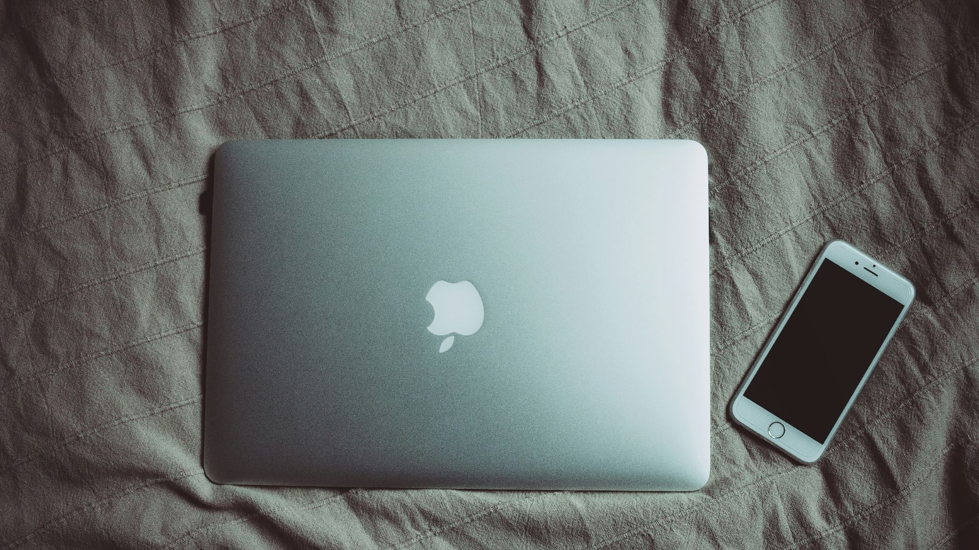 silver MacBook beside post-2014 iPhone