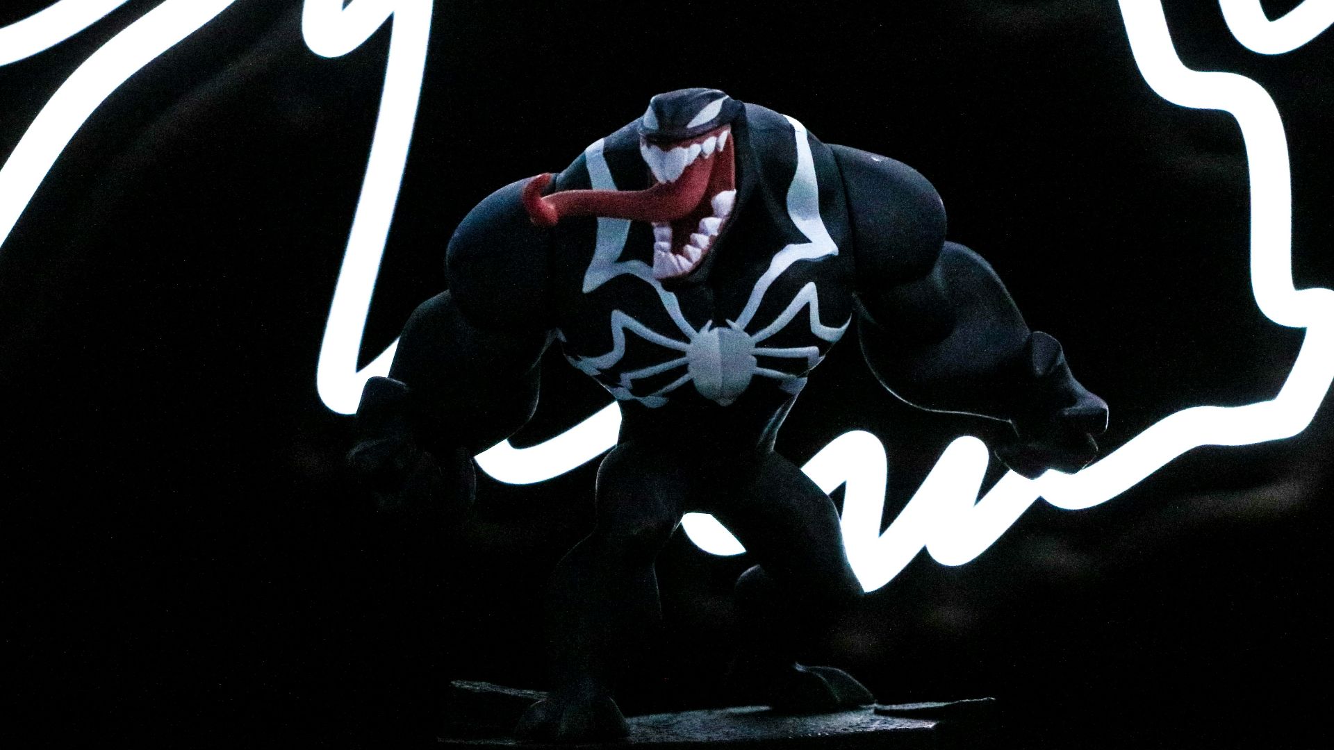 a spider - man figure is posed in front of a neon sign