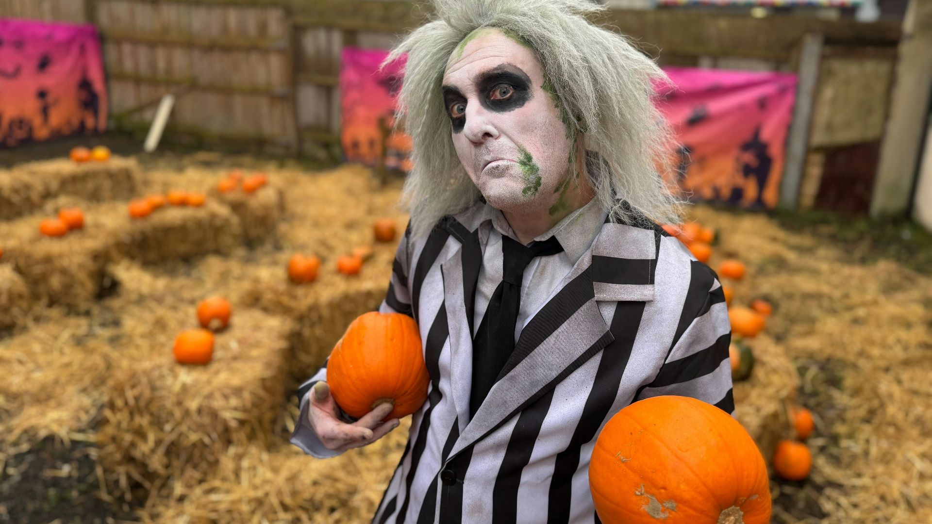 A man dressed in a costume holding oranges