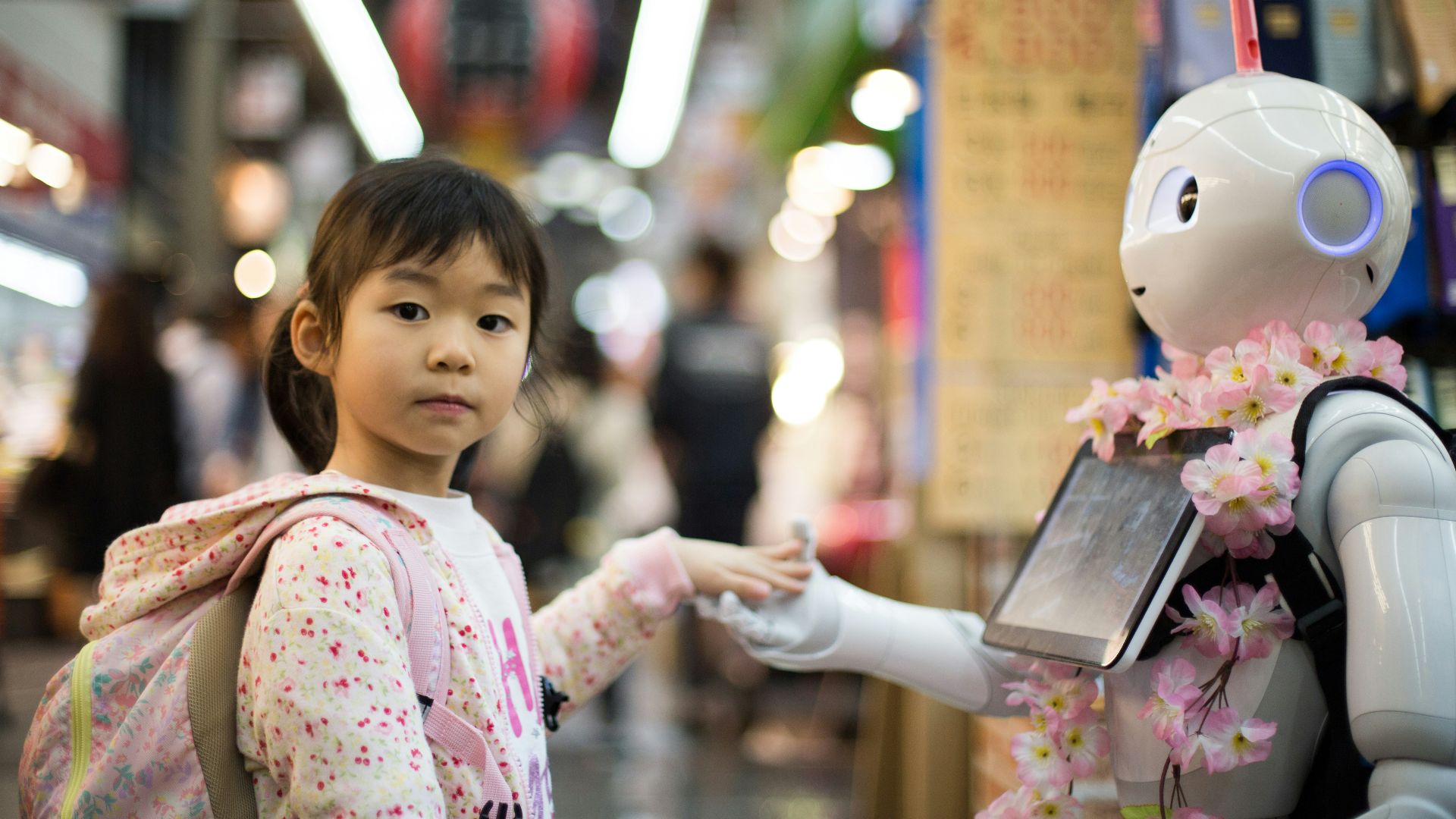 photo of girl laying left hand on white digital robot