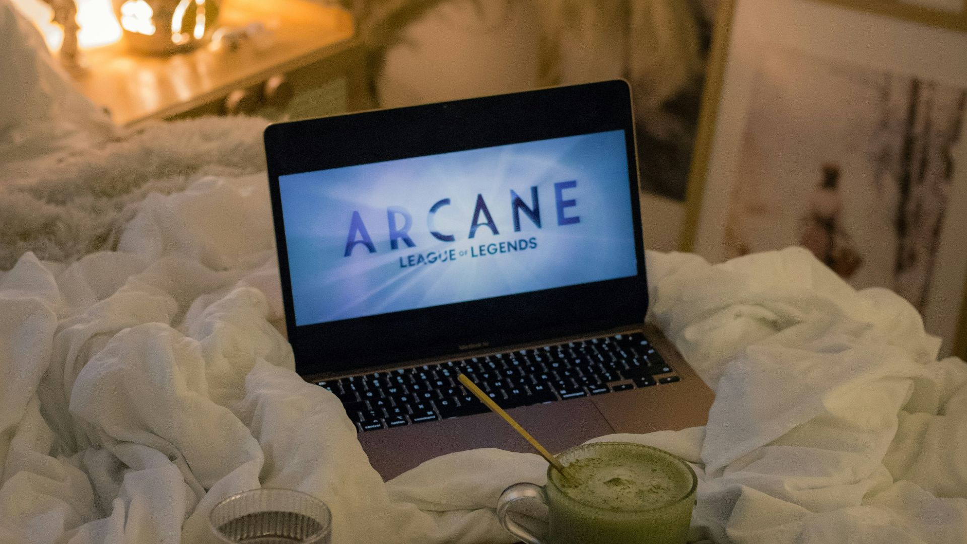 An open laptop computer sitting on top of a bed